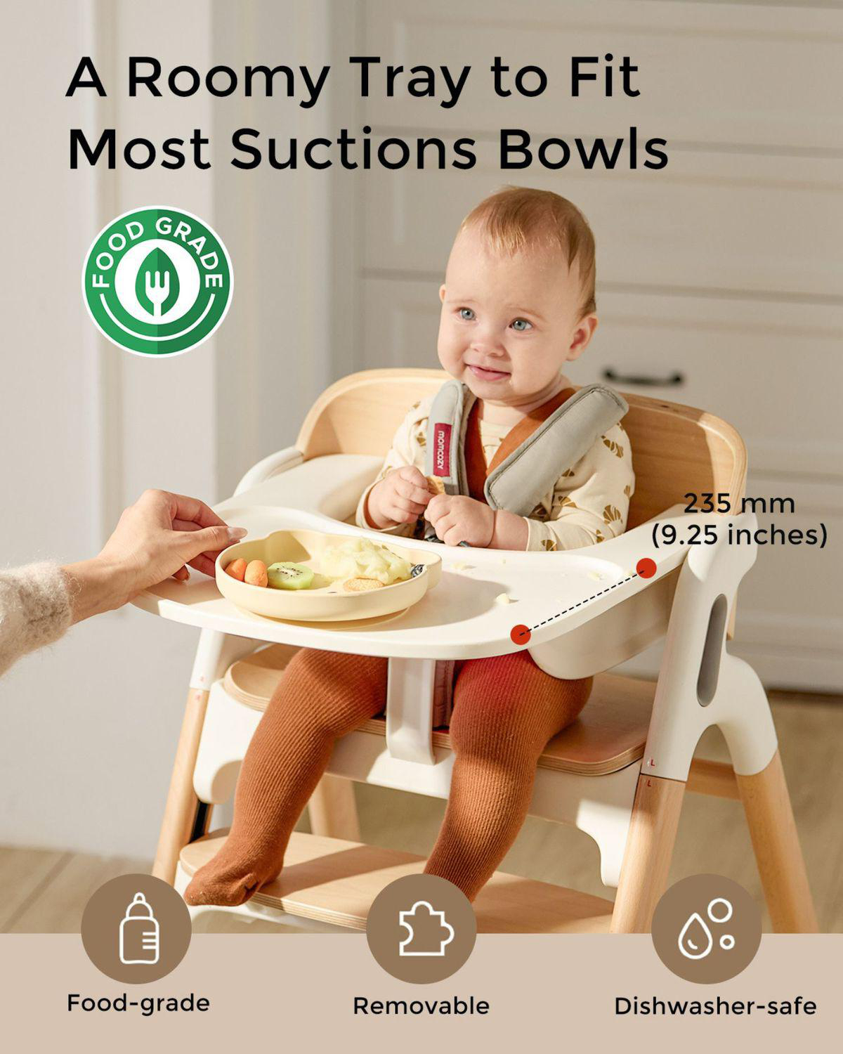 Ein Baby sitzt in einem Hochstuhl mit einem Tablett mit Essen. "Food-grade"-Symbol.