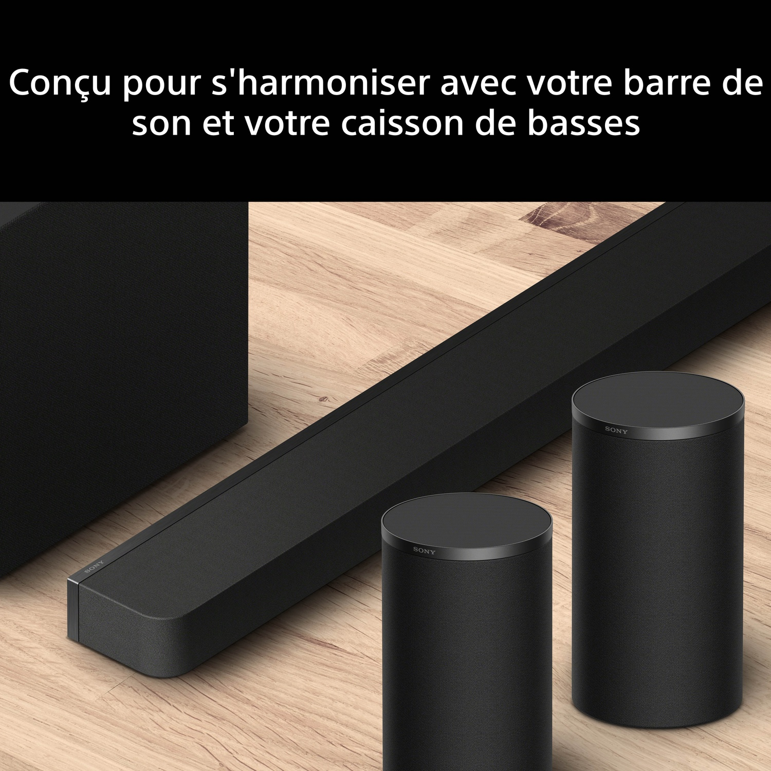 Barre de son Sony noire et deux enceintes cylindriques sur bois.