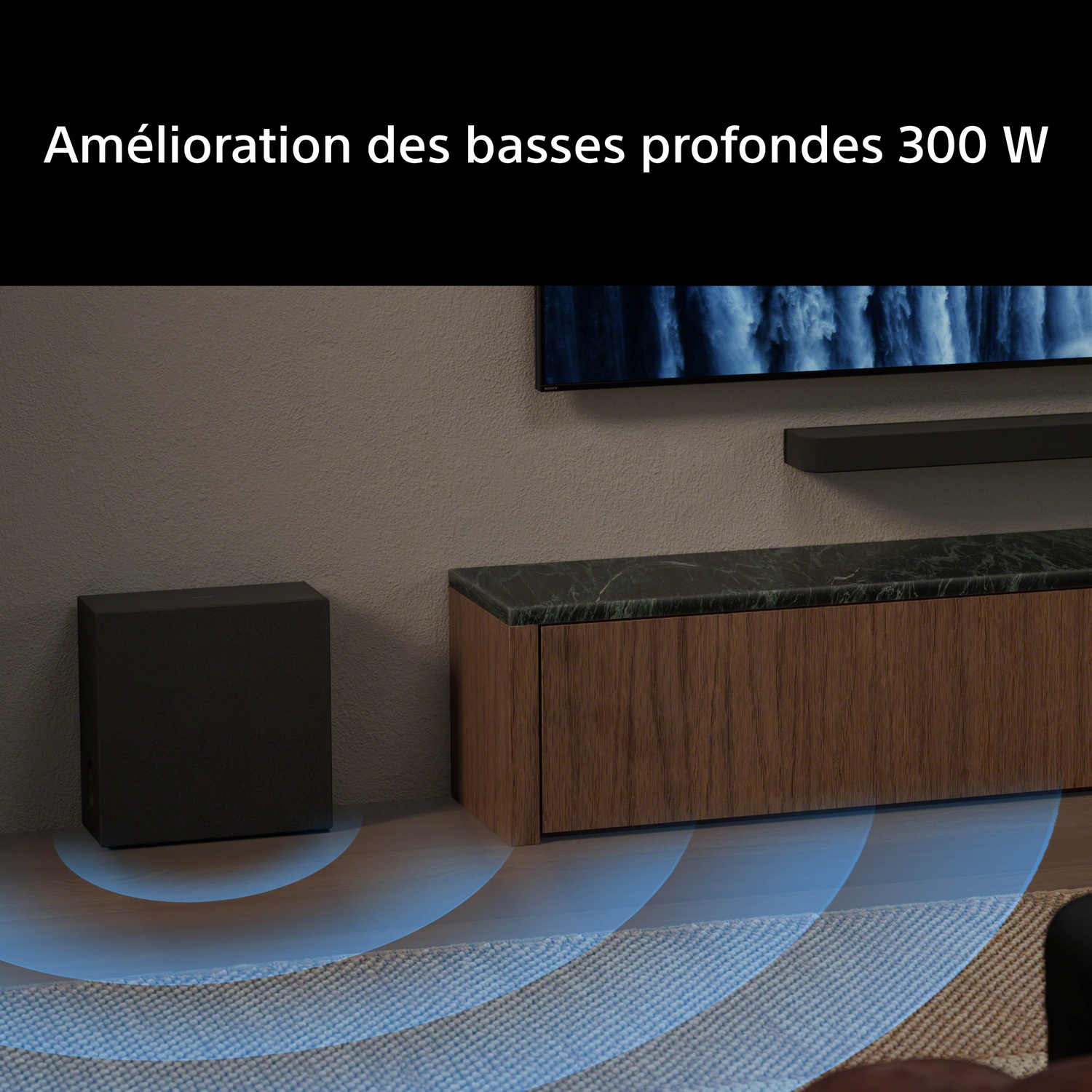 Un caisson de basse noir est posé sur un plancher à côté d'un meuble TV.