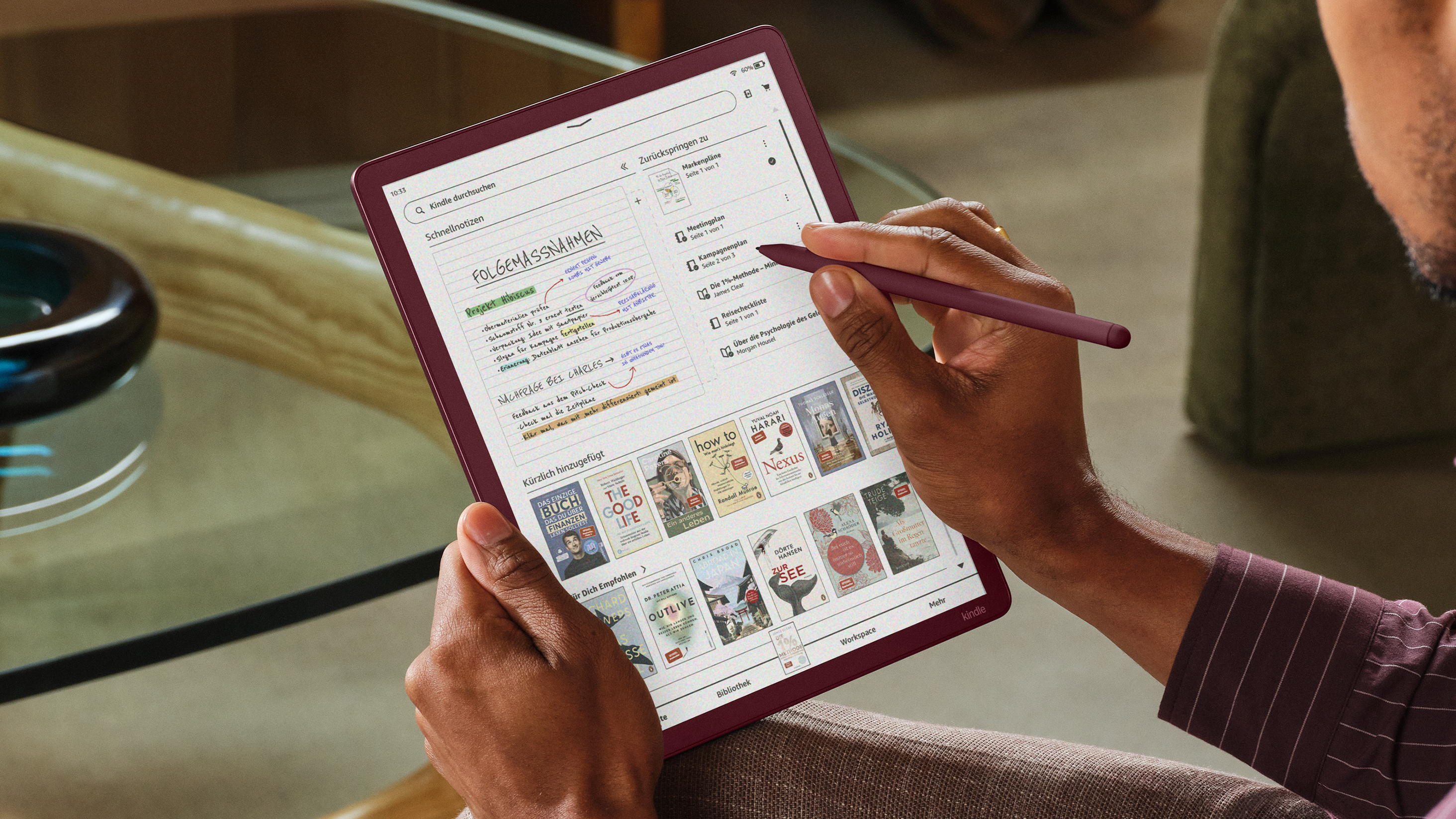 Person mit einem E-Reader und Stift, Notizen und Bücher auf dem Bildschirm.