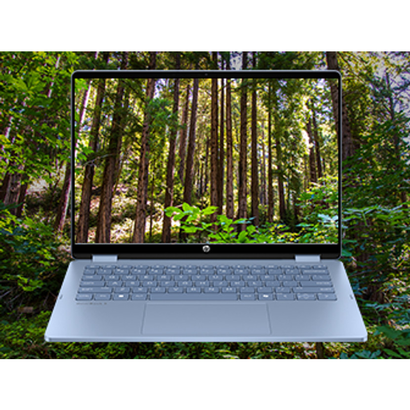 Laptop wyświetlający tapetę z lasem stoi na zewnątrz.
