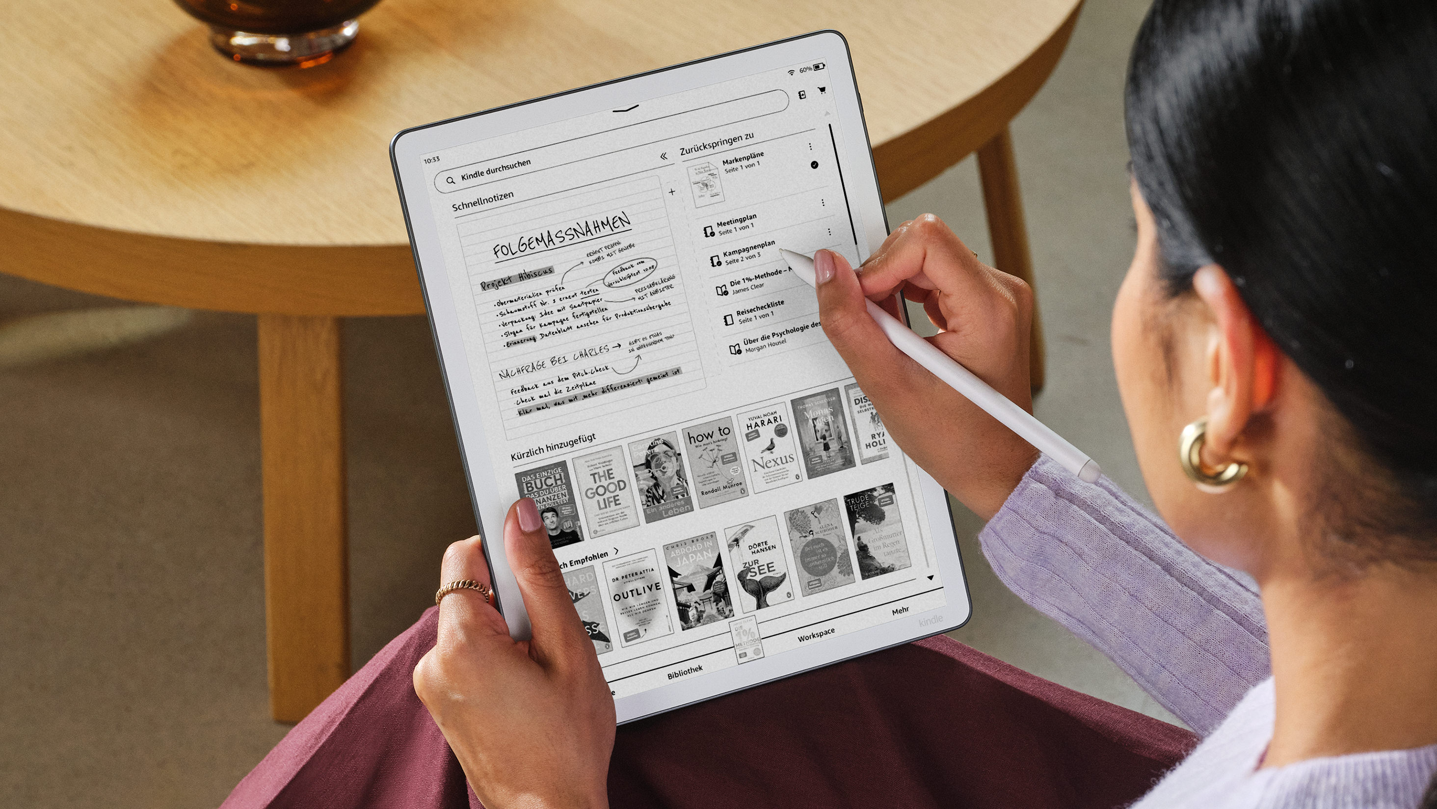 Eine Person benutzt einen E-Reader mit Notizen und Buchcovern auf dem Bildschirm.