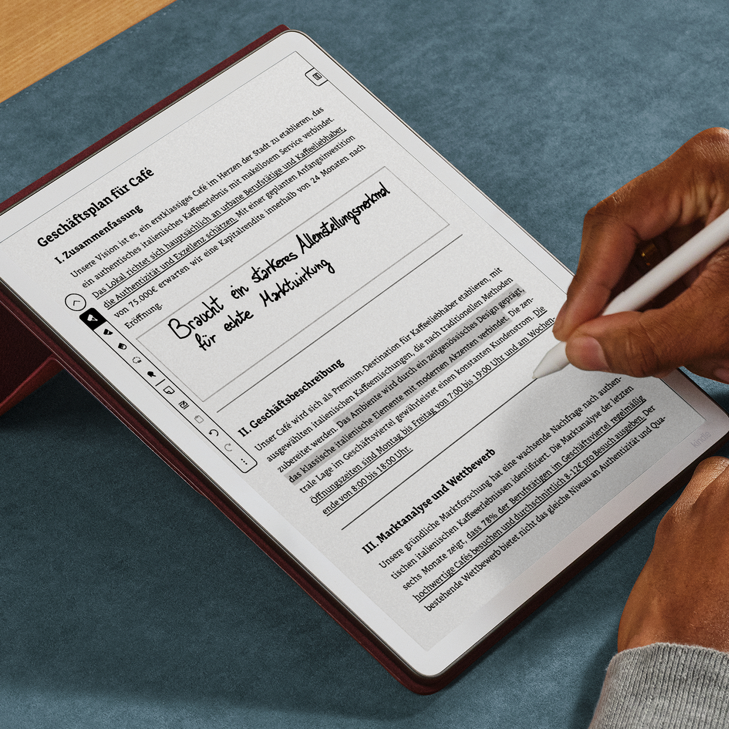 Eine Person schreibt mit einem Stift auf einem E-Reader-Display, das einen Geschäftsplan zeigt.