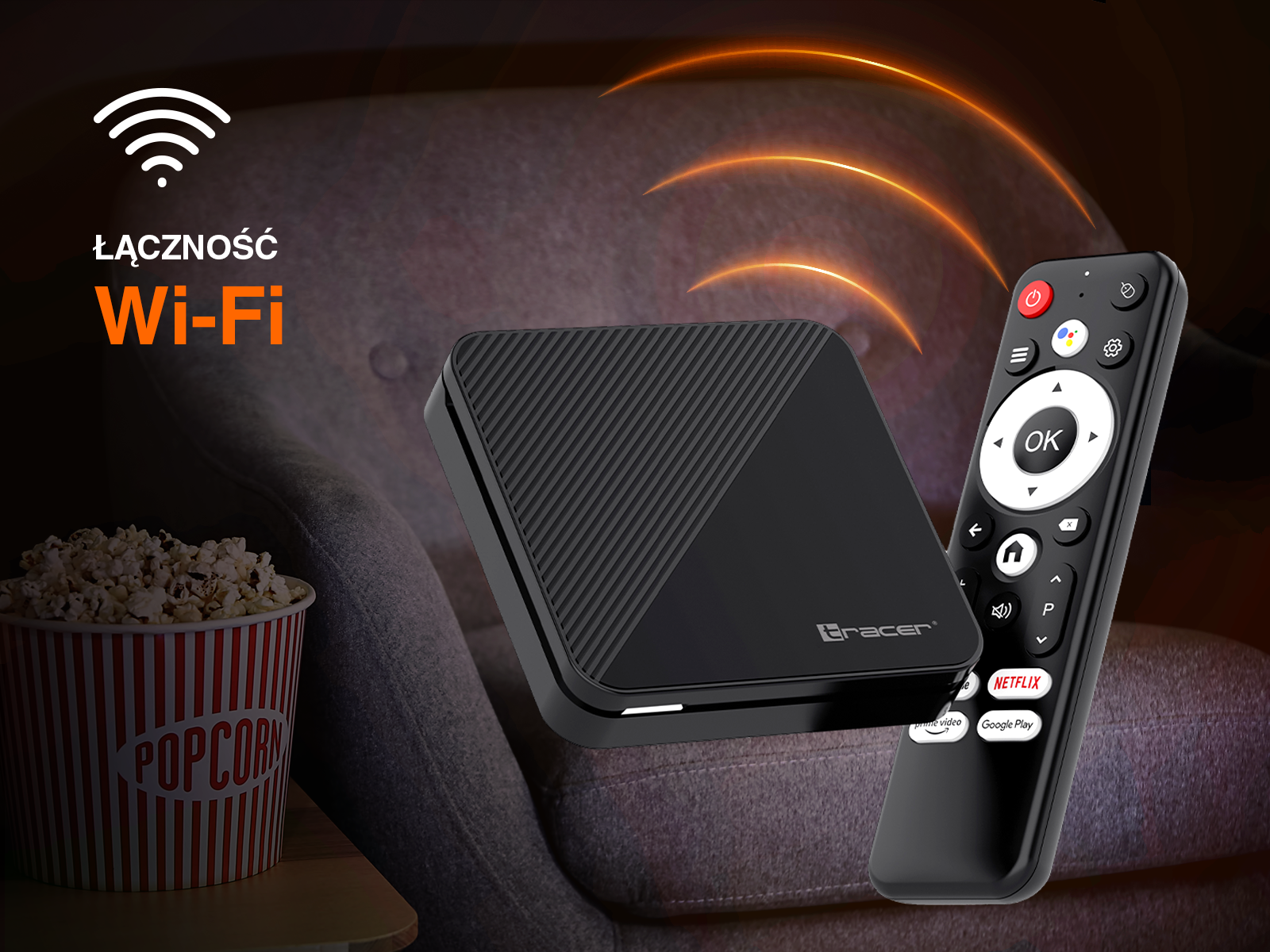 Czarny odtwarzacz multimedialny i pilot leżą obok miski popcornu.