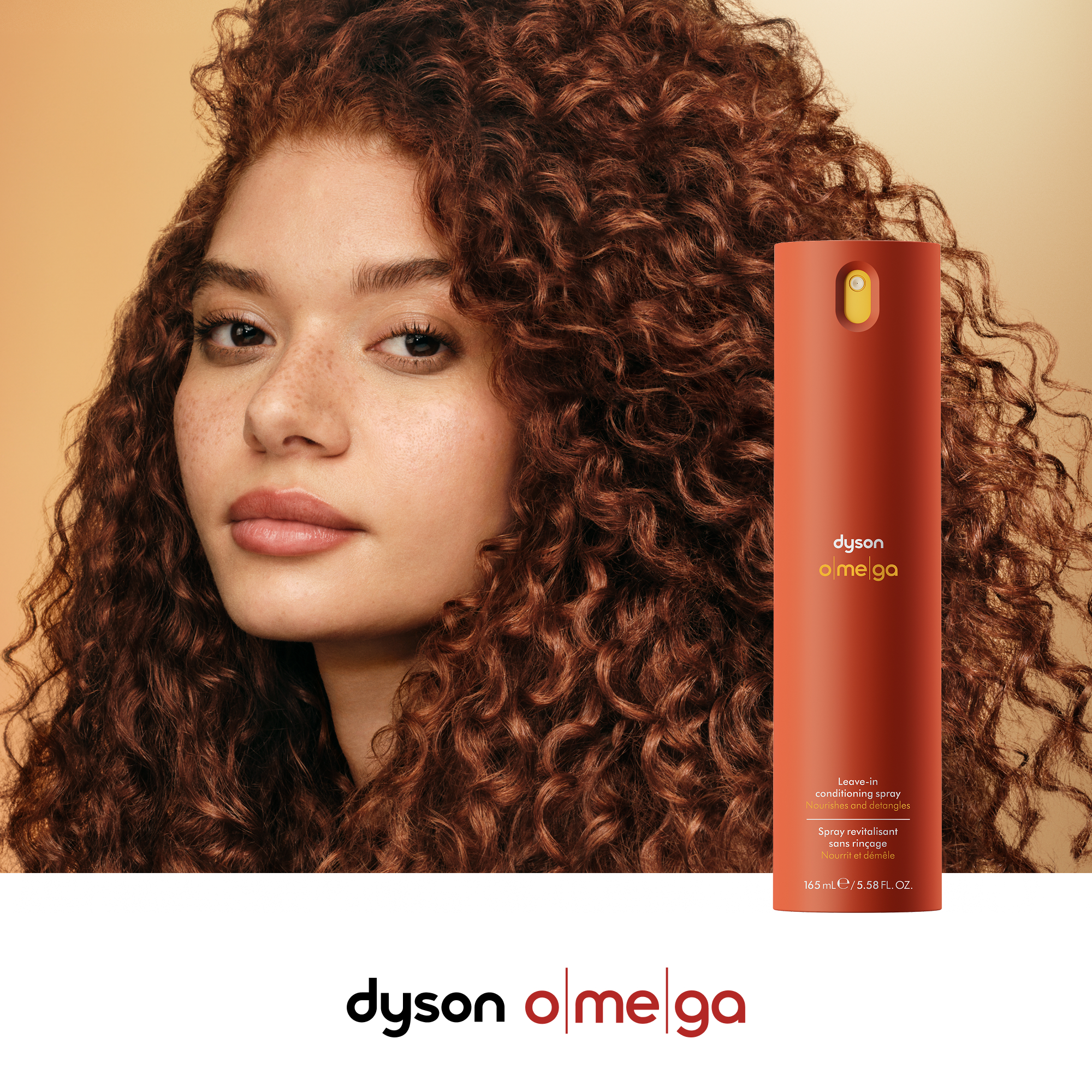 Eine Frau mit lockigem Haar neben einem orangen Dyson-Spray.
