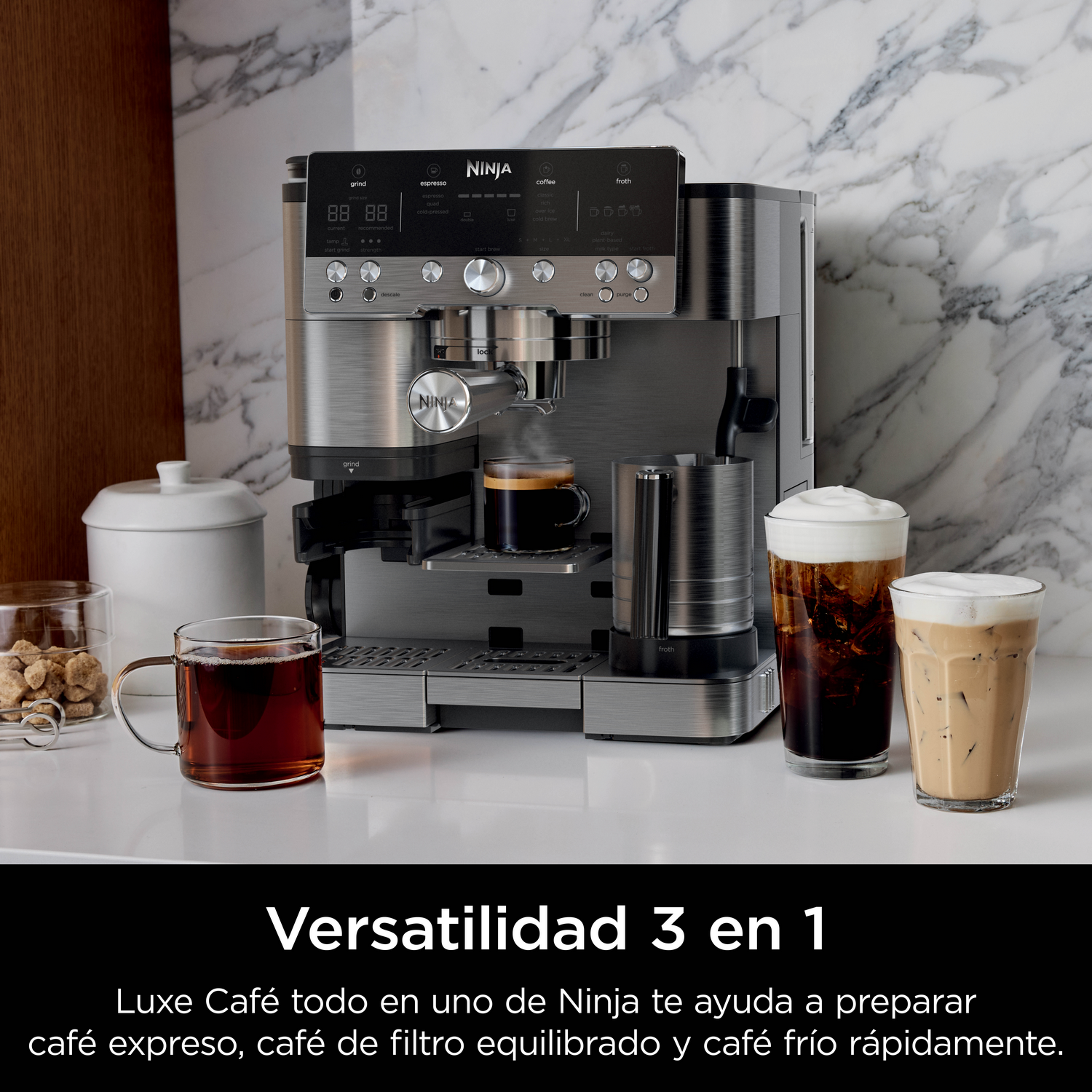 Una cafetera Ninja plateada con tres bebidas: espresso, café helado y leche espumosa.