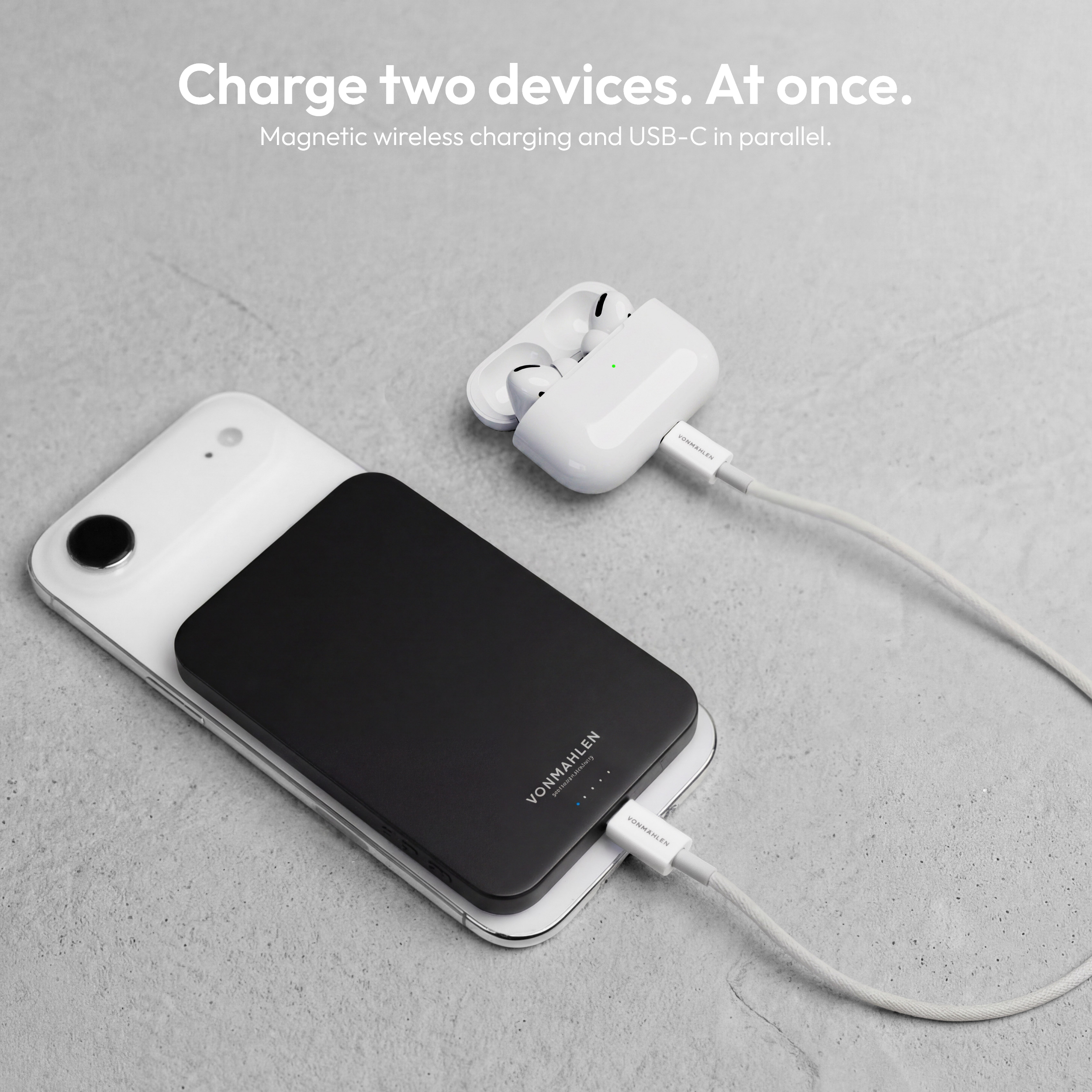 Schwarzes Ladegerät lädt ein iPhone und AirPods Pro mit Kabel.