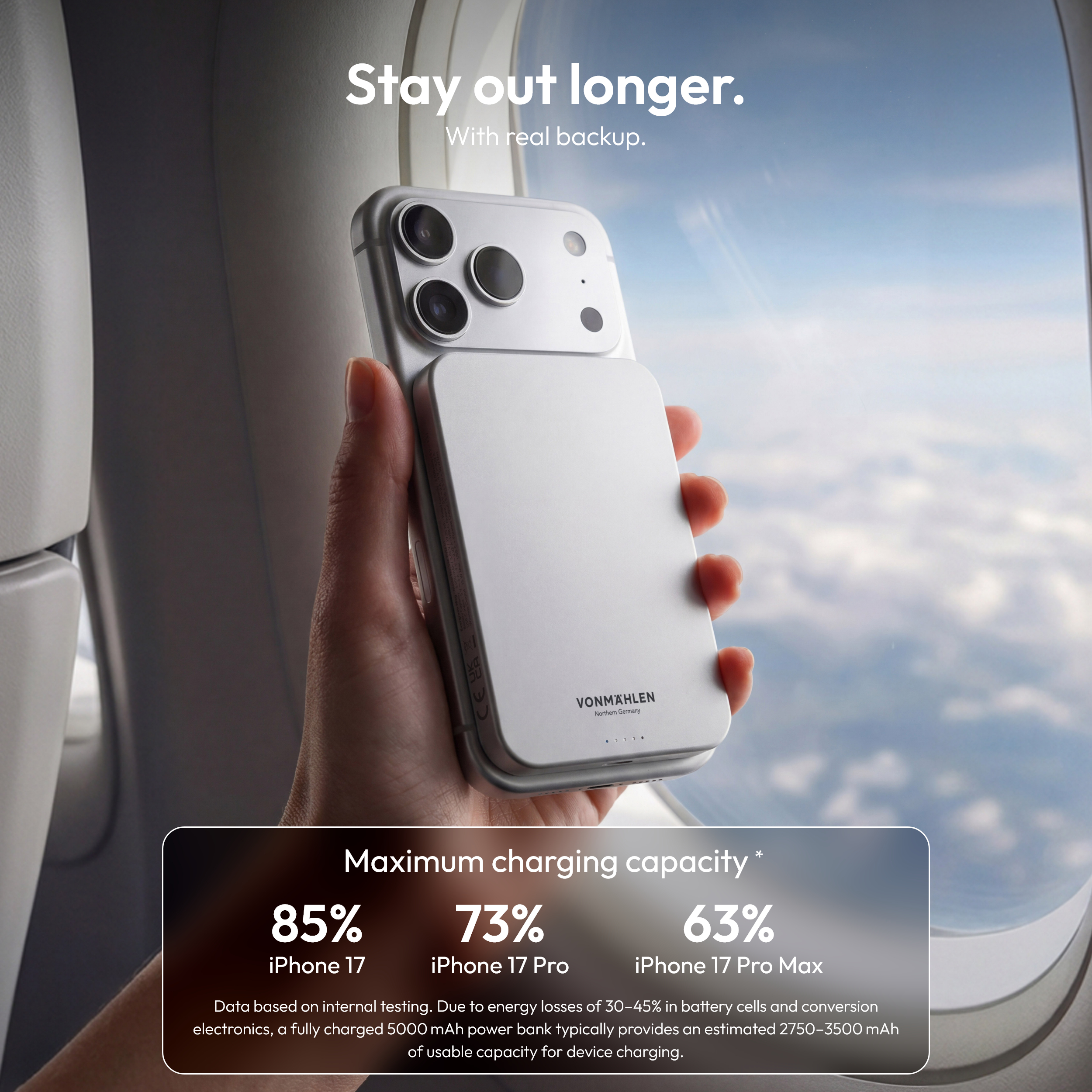Person hält ein silbernes iPhone mit angebrachtem Akku im Flugzeug.