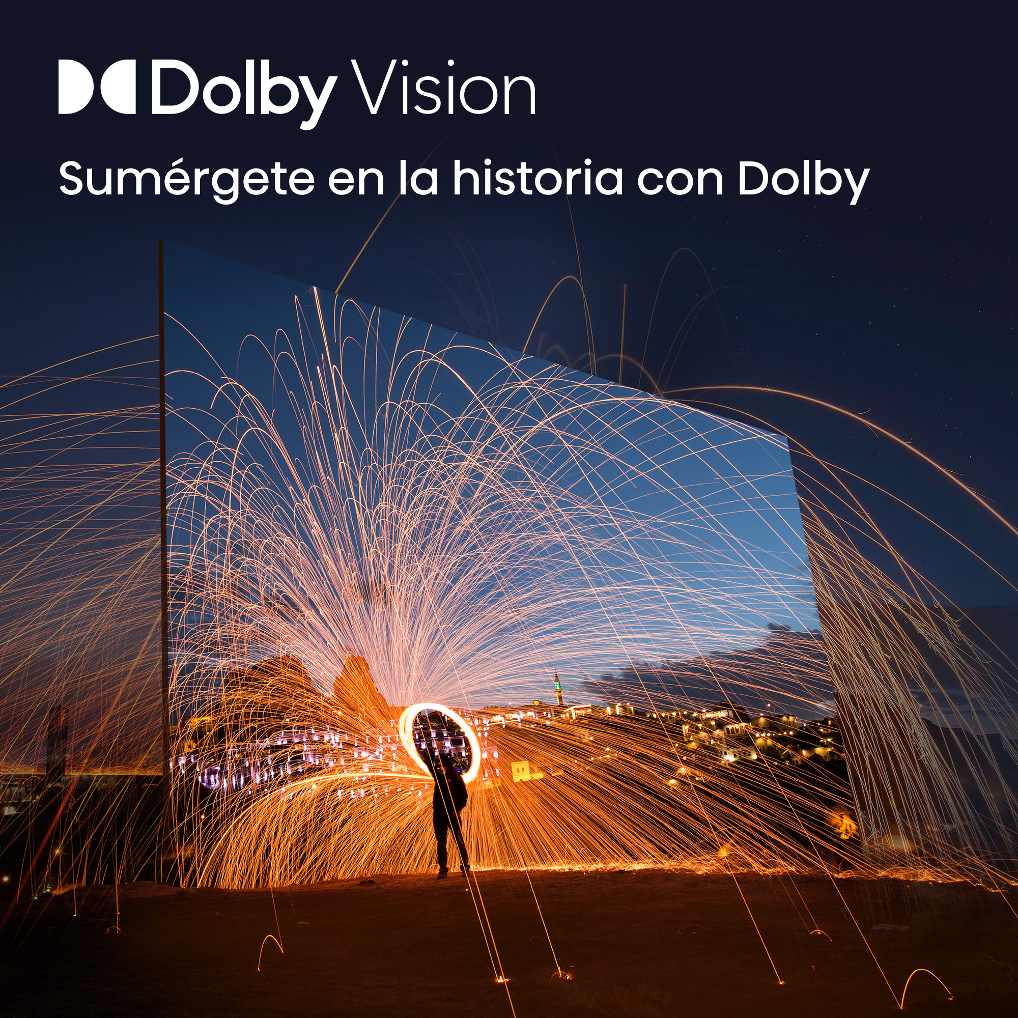 Una persona hace girar fuegos artificiales que crean un círculo de luz ante una ciudad nocturna.