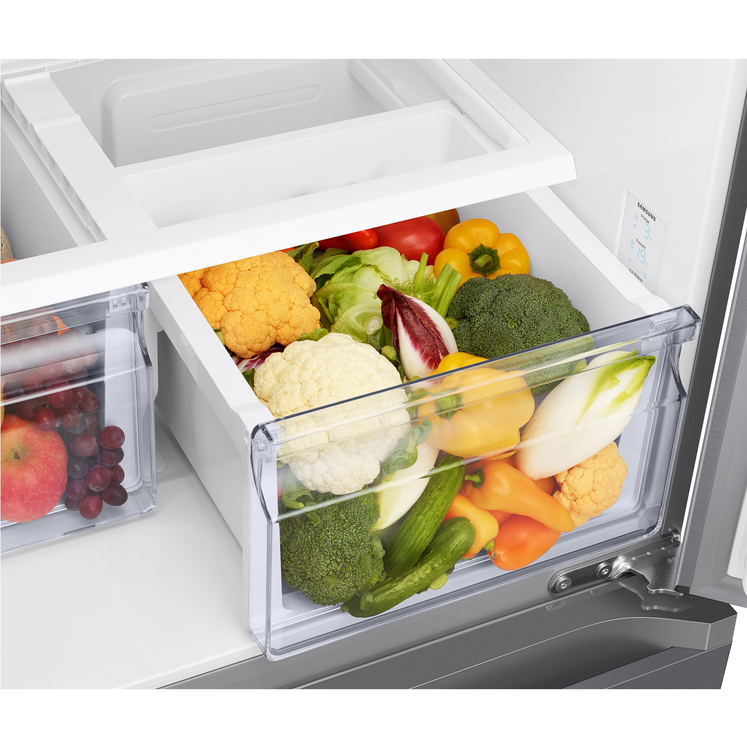 Cajón de verduras del refrigerador con brócoli, coliflor, pimientos y lechuga frescos.