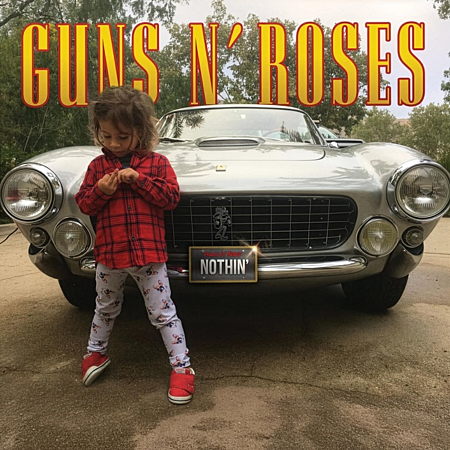 Een kind staat voor een oldtimer met de tekst GUNS N' ROSES.