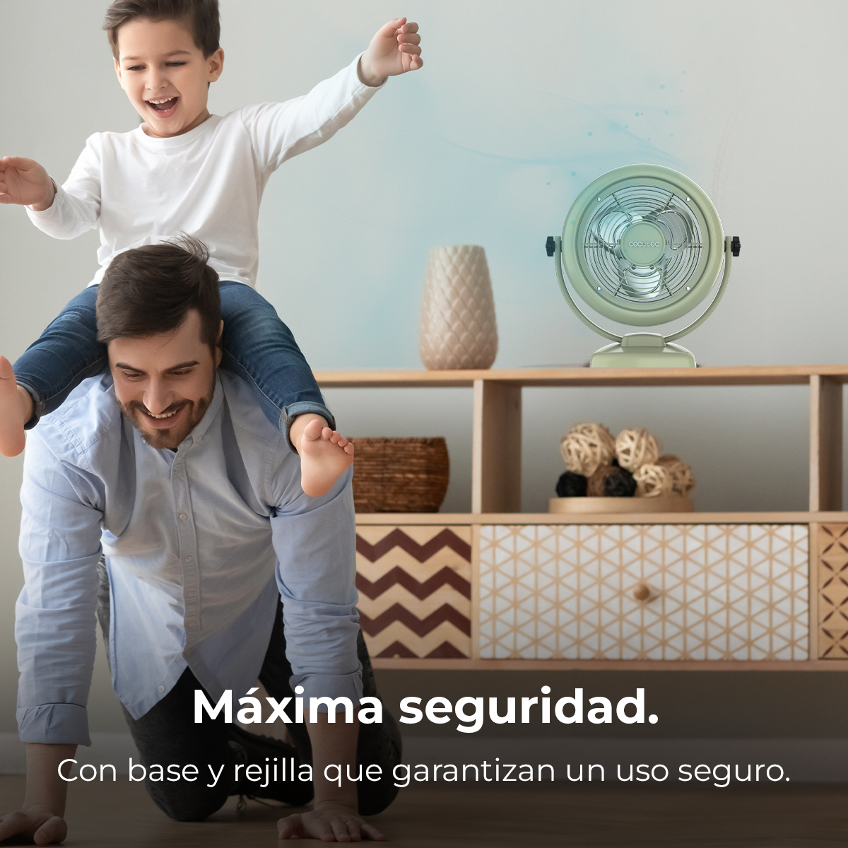 Un padre lleva a su hijo en hombros, un ventilador en un estante.