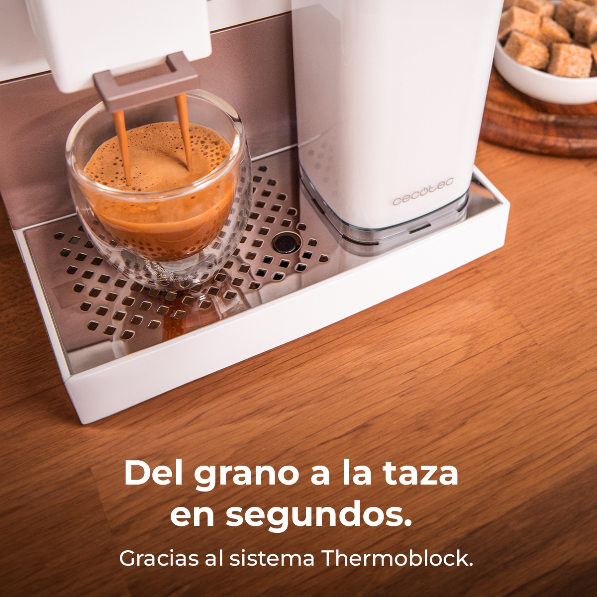 Máquina de espresso preparando café en un vaso, junto a depósito de agua y terrones.