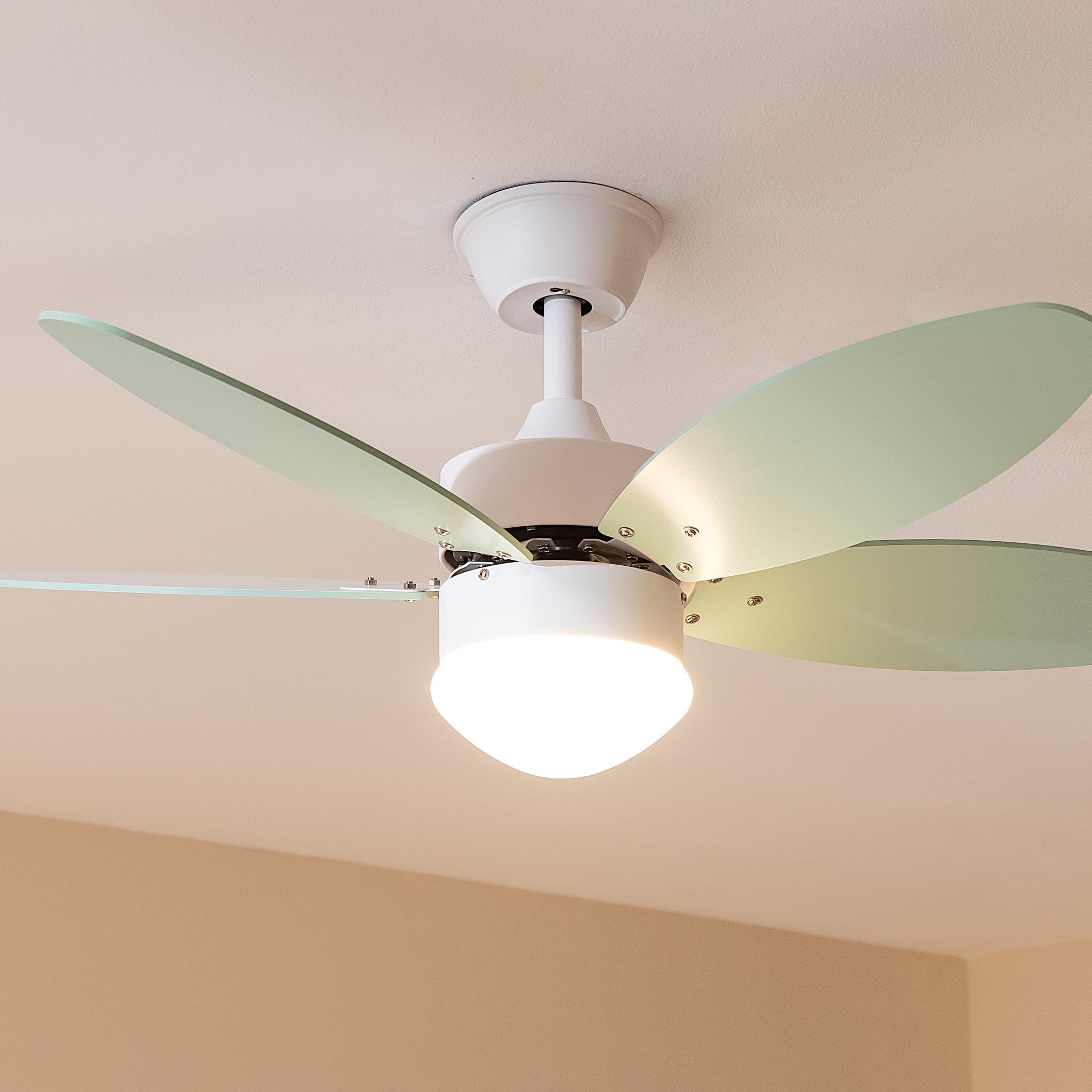 Una lámpara de ventilador de techo blanca con aspas verde pálido y bombilla iluminada.