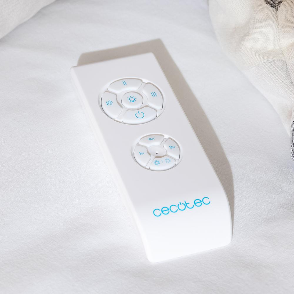 Un mando a distancia blanco con botones azules y un logo descansa sobre tela blanca.
