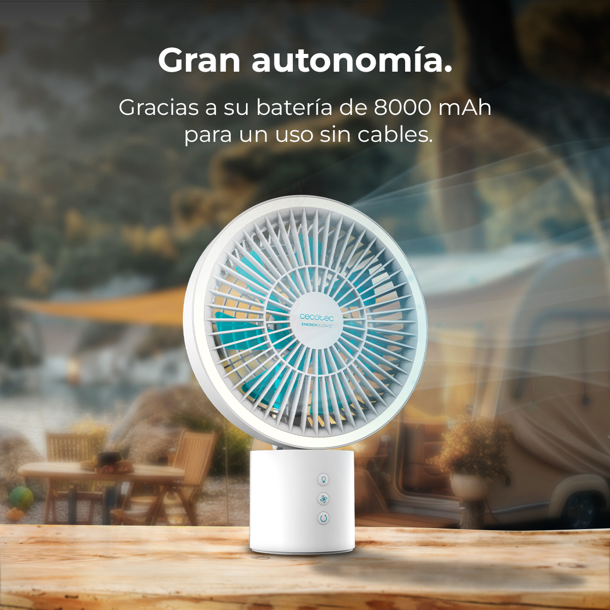 Un ventilador blanco con aspas azules se asienta sobre una mesa de madera al aire libre.