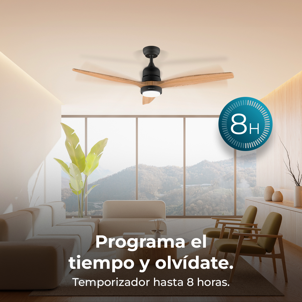 Un ventilador de techo con aspas de madera cuelga sobre una sala con sofás.