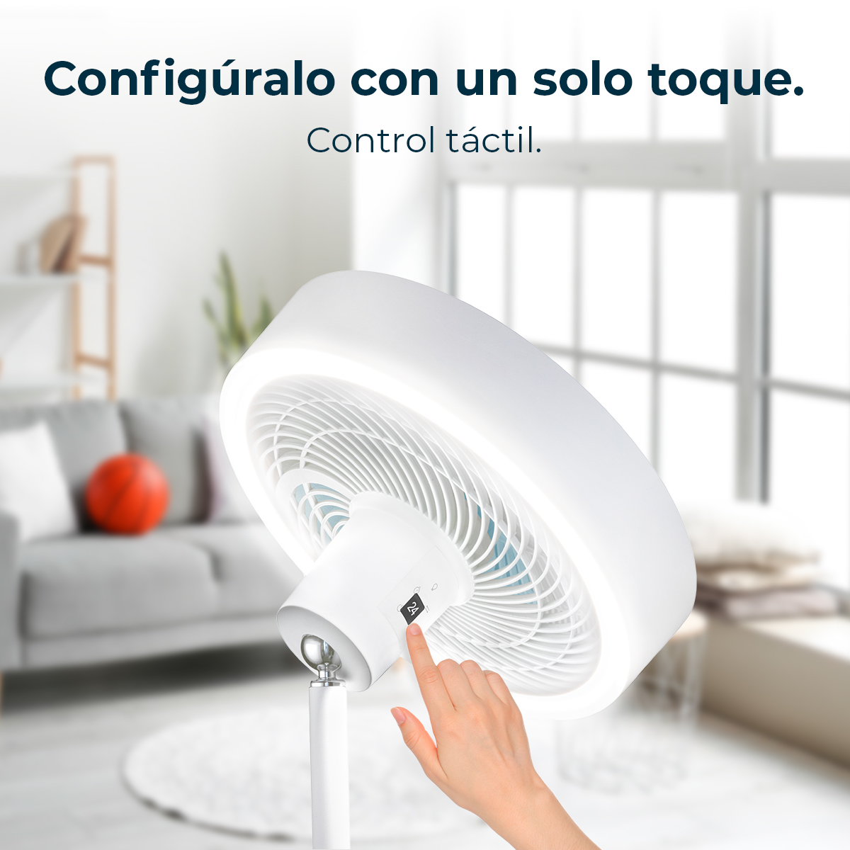 Una mano acciona un ventilador blanco con pantalla táctil en una sala.