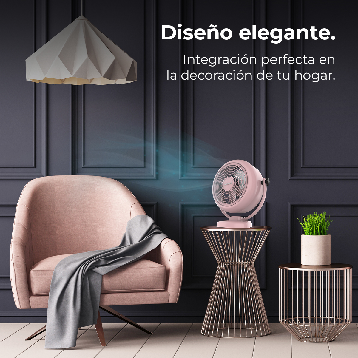 Un ventilador rosa está en una mesa auxiliar junto a un sillón con una manta.