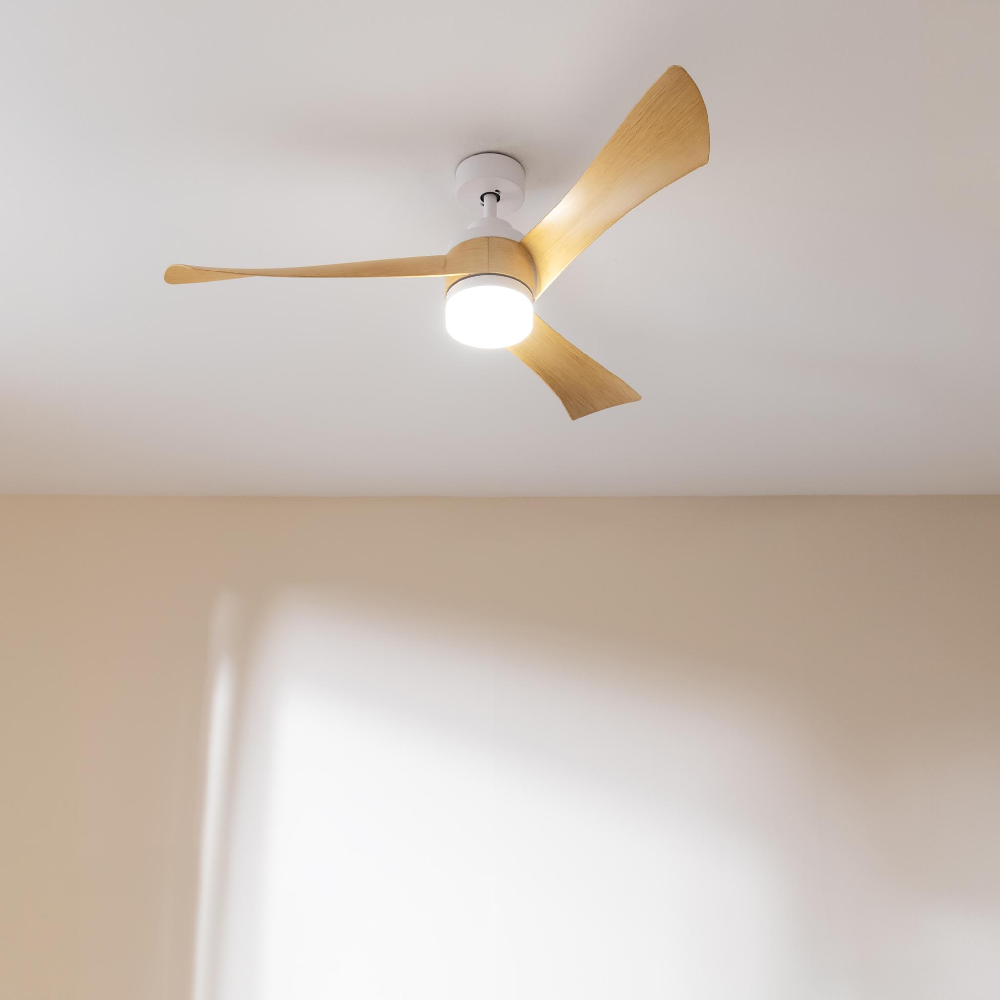 Un ventilador de techo moderno con aspas de madera y luz integrada.