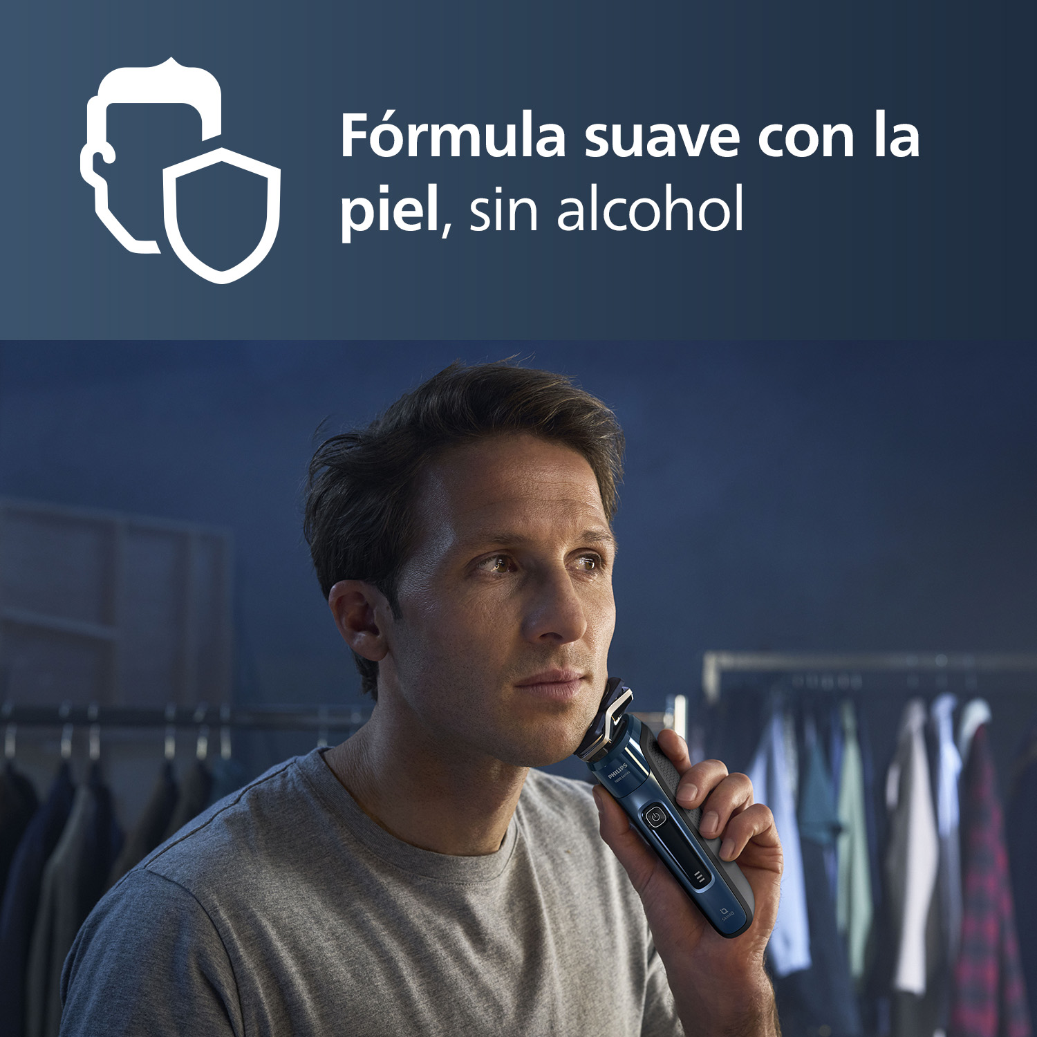 Hombre usando afeitadora Philips frente al armario. Texto: Fórmula suave con la piel, sin alcohol.