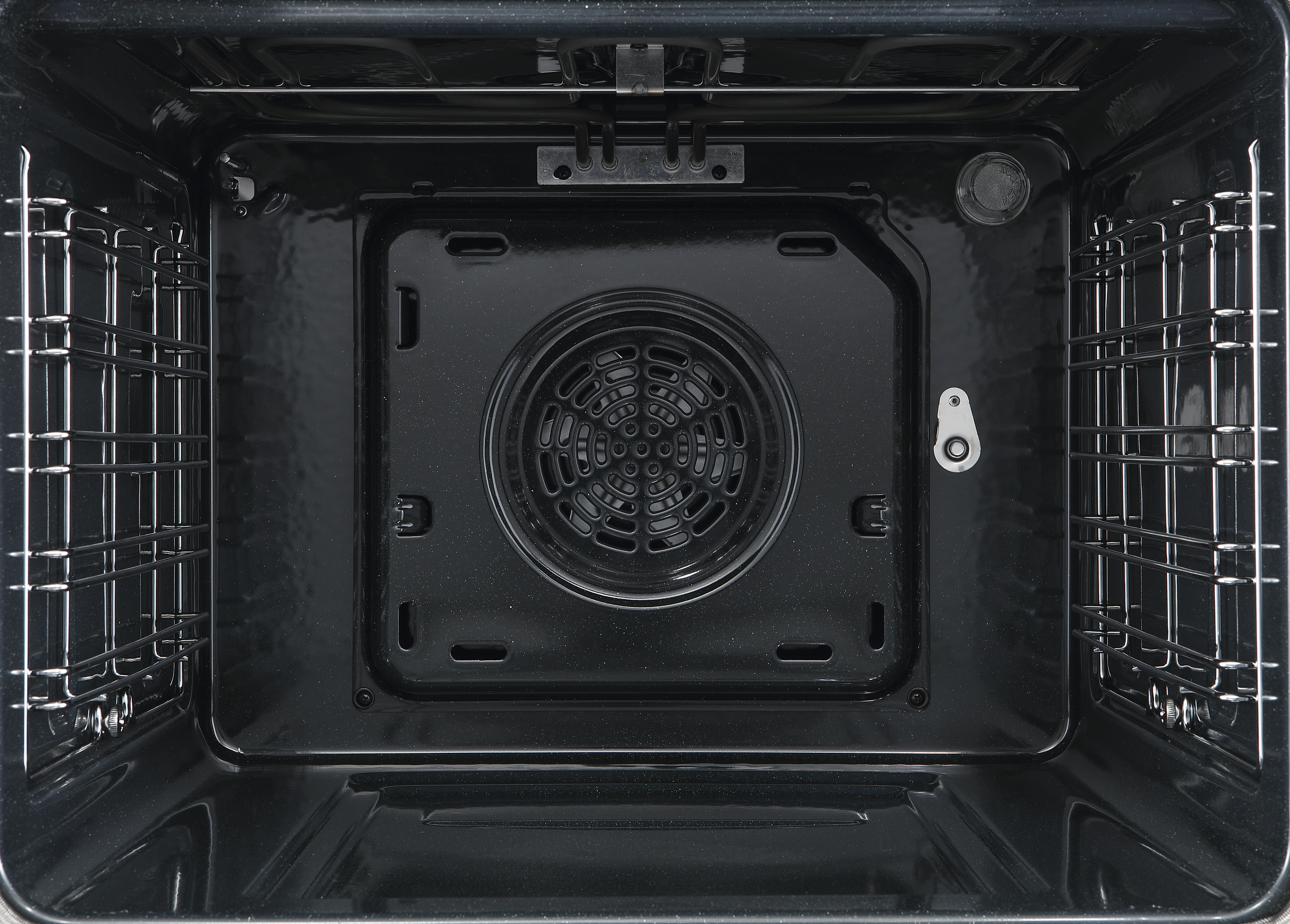 Wnętrze czystego, czarnego piekarnika z rusztami i wentylatorem.
