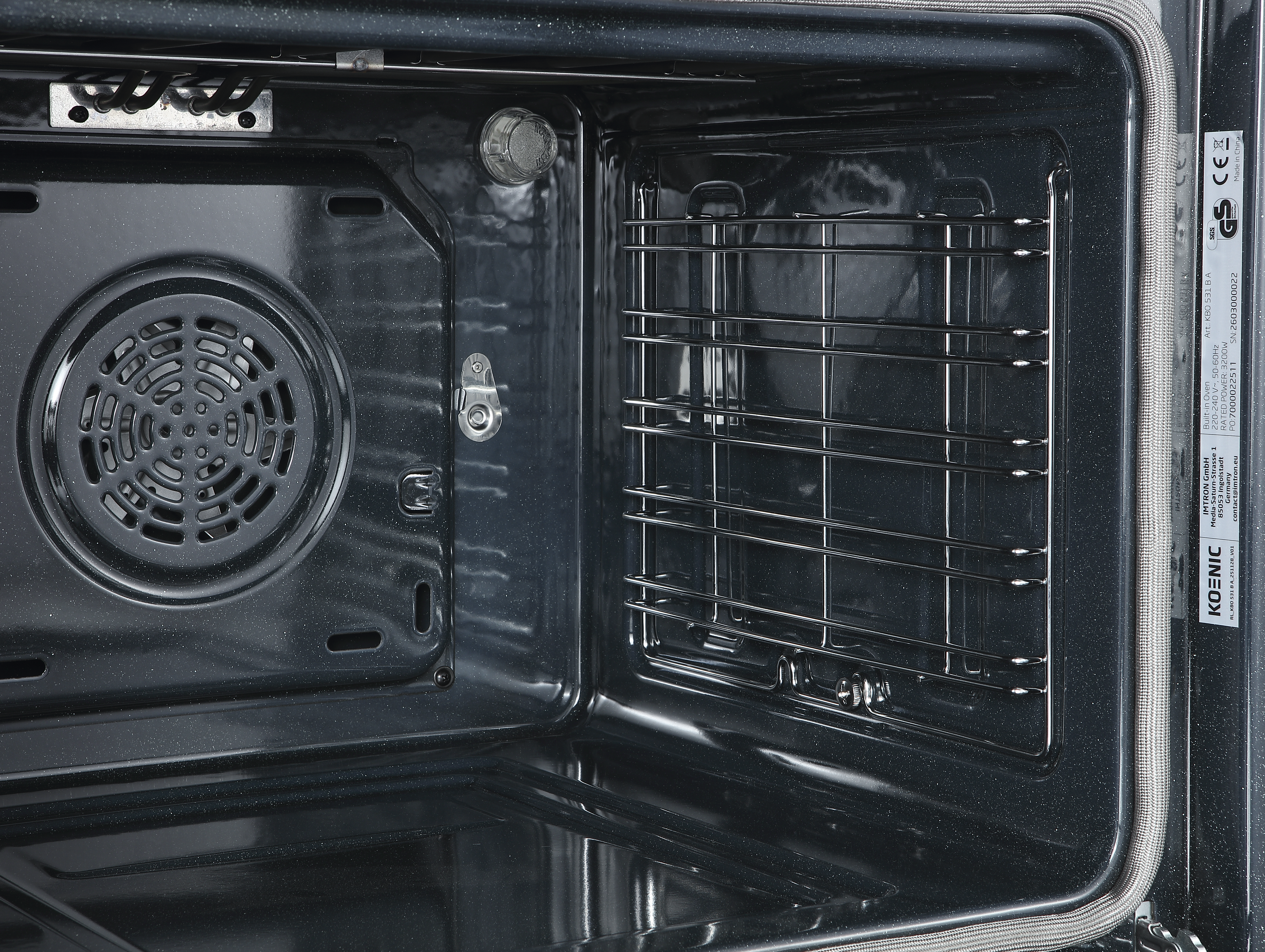 Wnętrze czystego, ciemnego piekarnika z wentylatorem i rusztem.