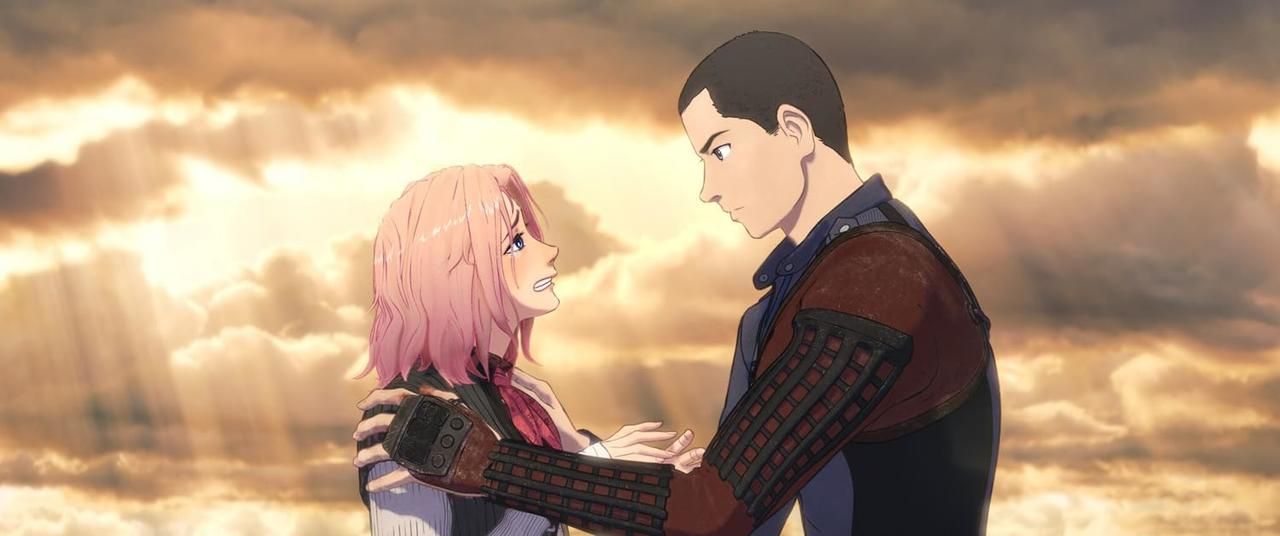 Ein Mann mit kurzem Haar und eine Frau mit rosa Haaren umarmen sich vor einem dramatischen Himmel.