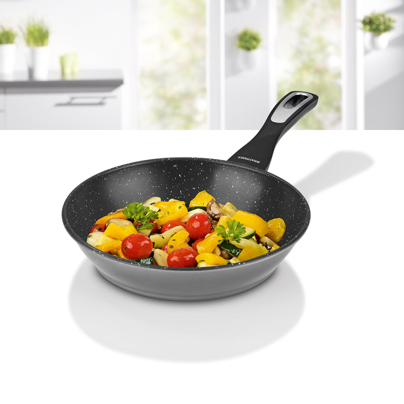 Bratpfanne mit sautiertem Gemüse, darunter Tomaten, Paprika und Zucchini.