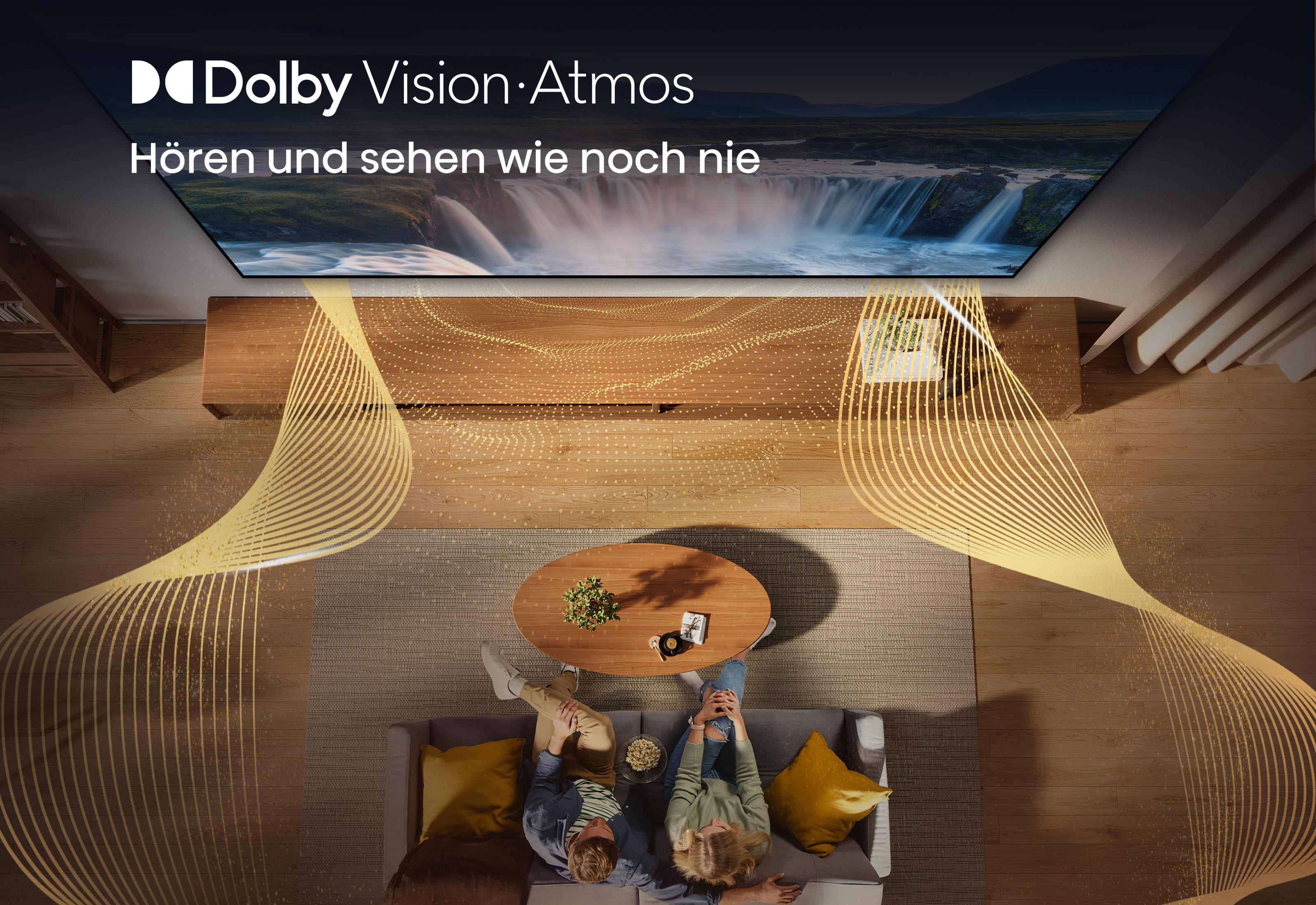 Paar auf Sofa schaut Fernseher mit Wasserfallbild. Dolby Vision Atmos.