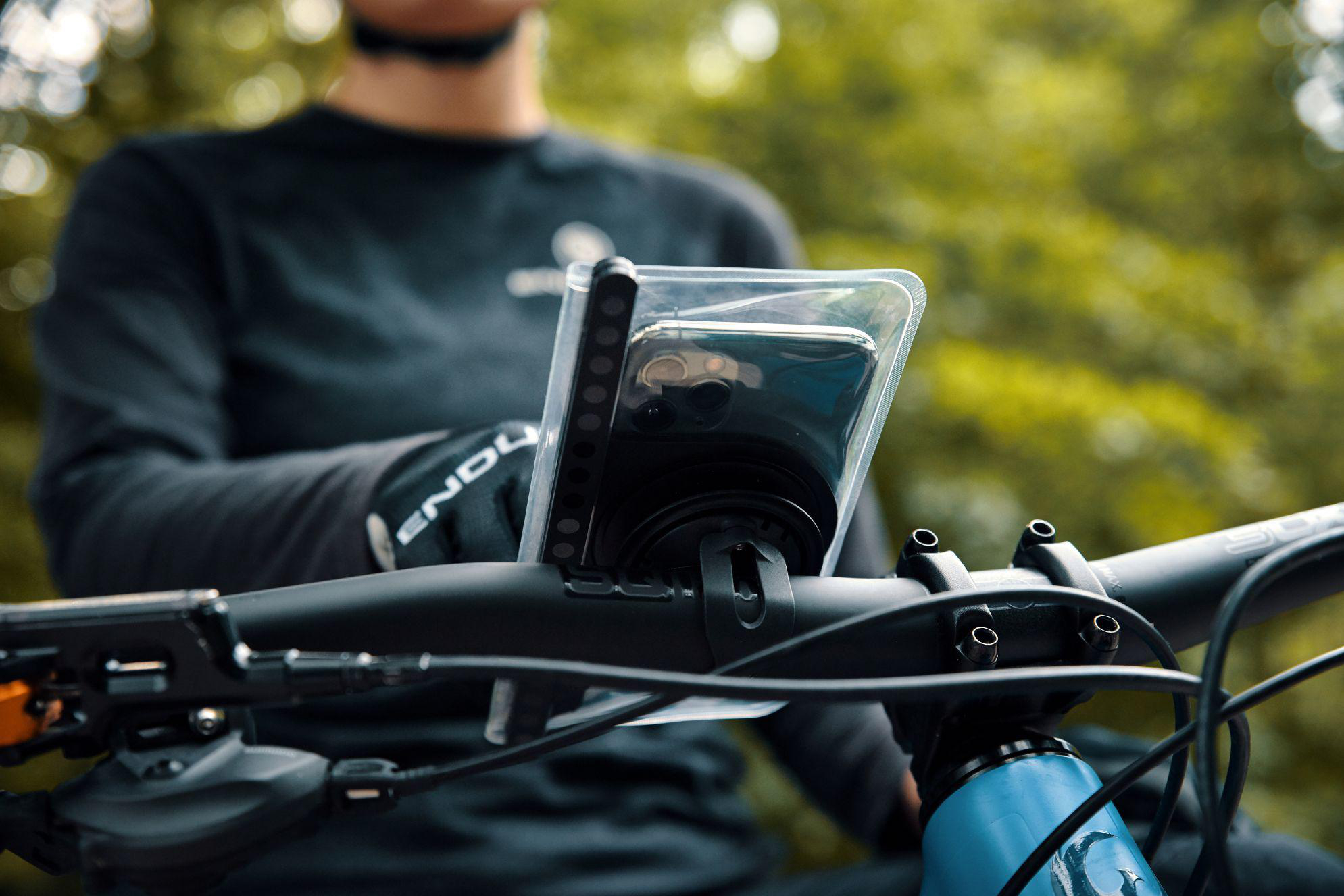 Ein Mountainbiker mit Handyhalterung am Lenker, im Freien.
