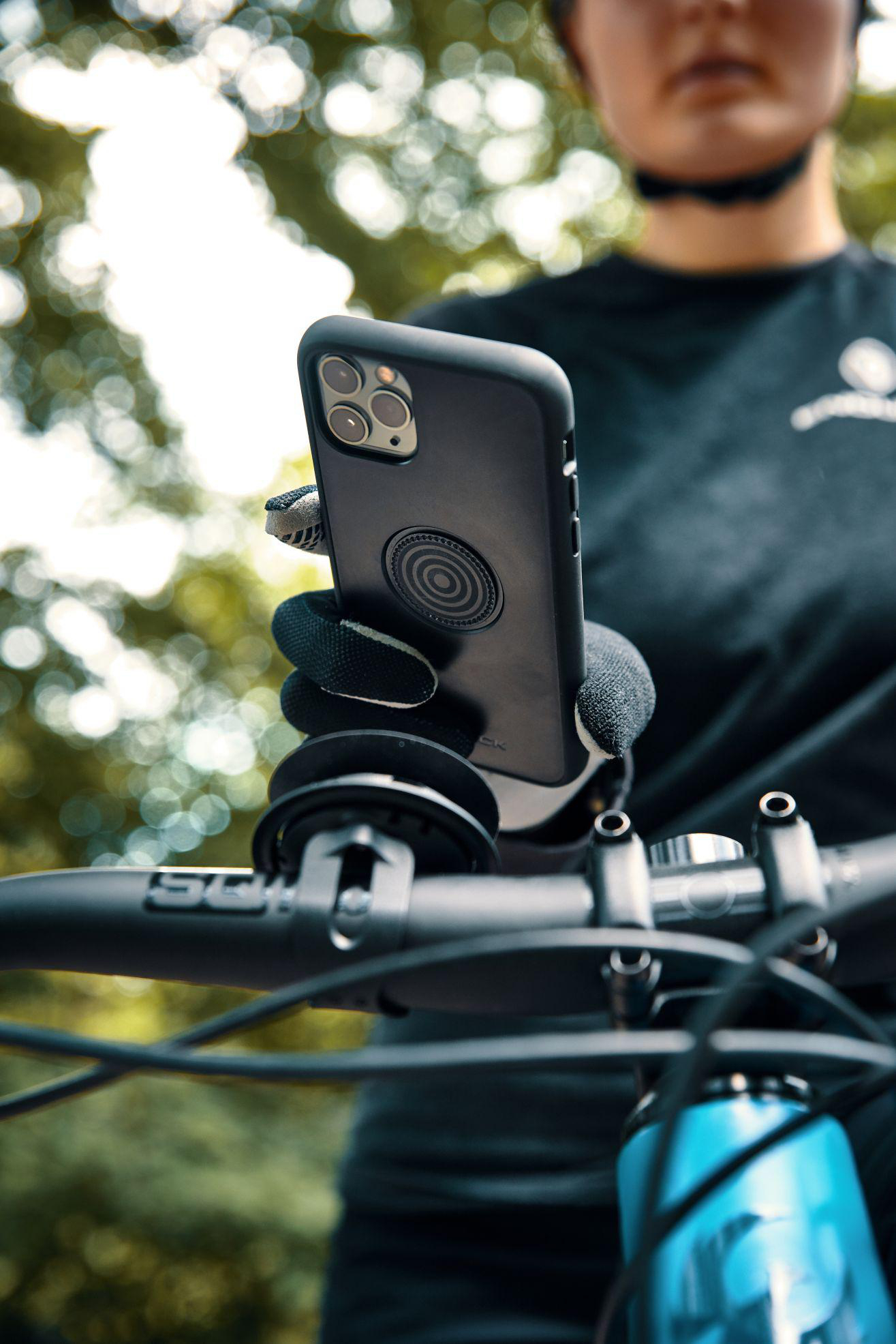 Fahrradlenker mit Handyhalterung und Person im Hintergrund.