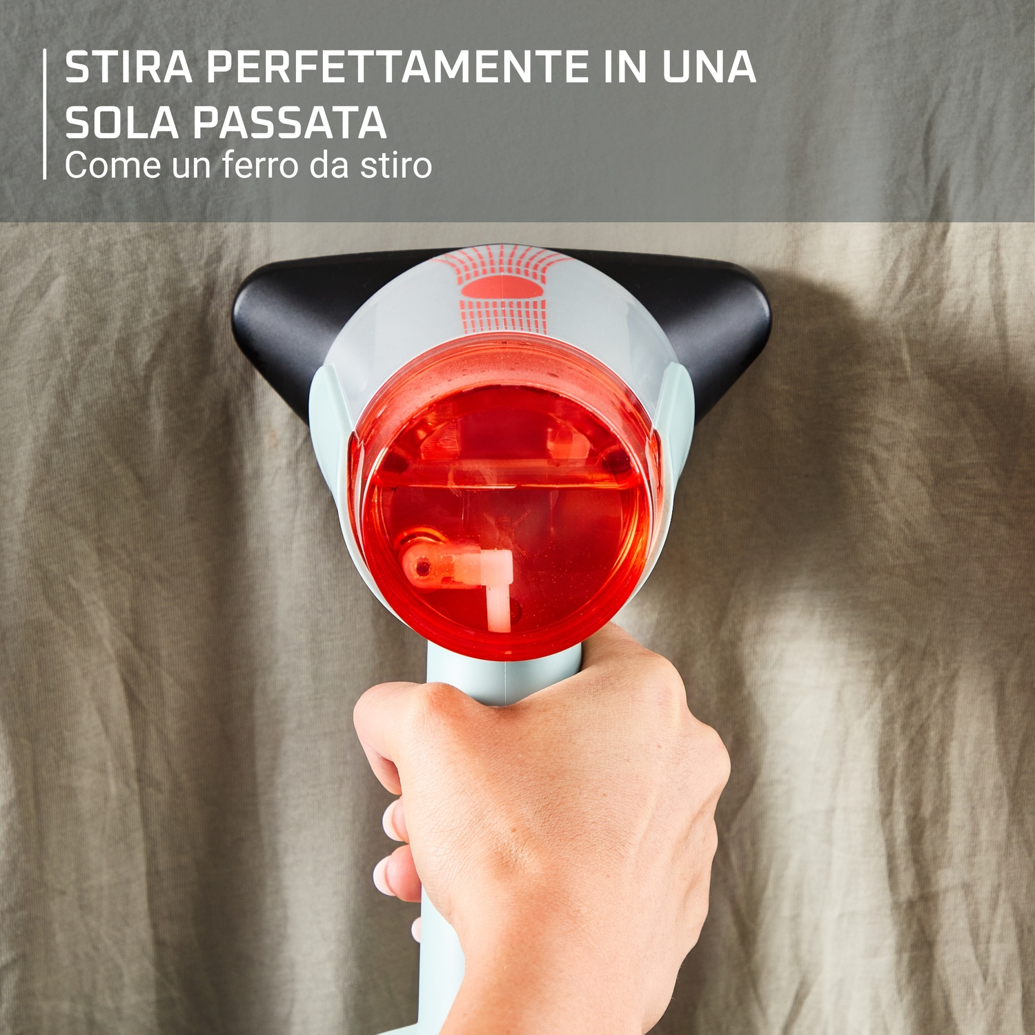 Mano che tiene ferro da stiro a vapore su tessuto stropicciato, rosso e bianco.