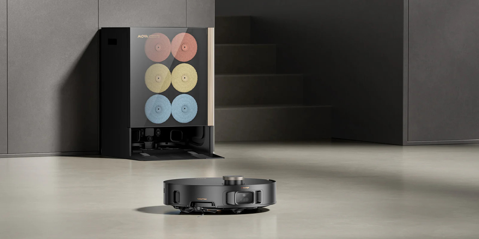 Czarny robot sprzątający stoi na jasnoszarym podłodze przed czarną stacją dokującą z sześcioma okrągłymi szczotkami.