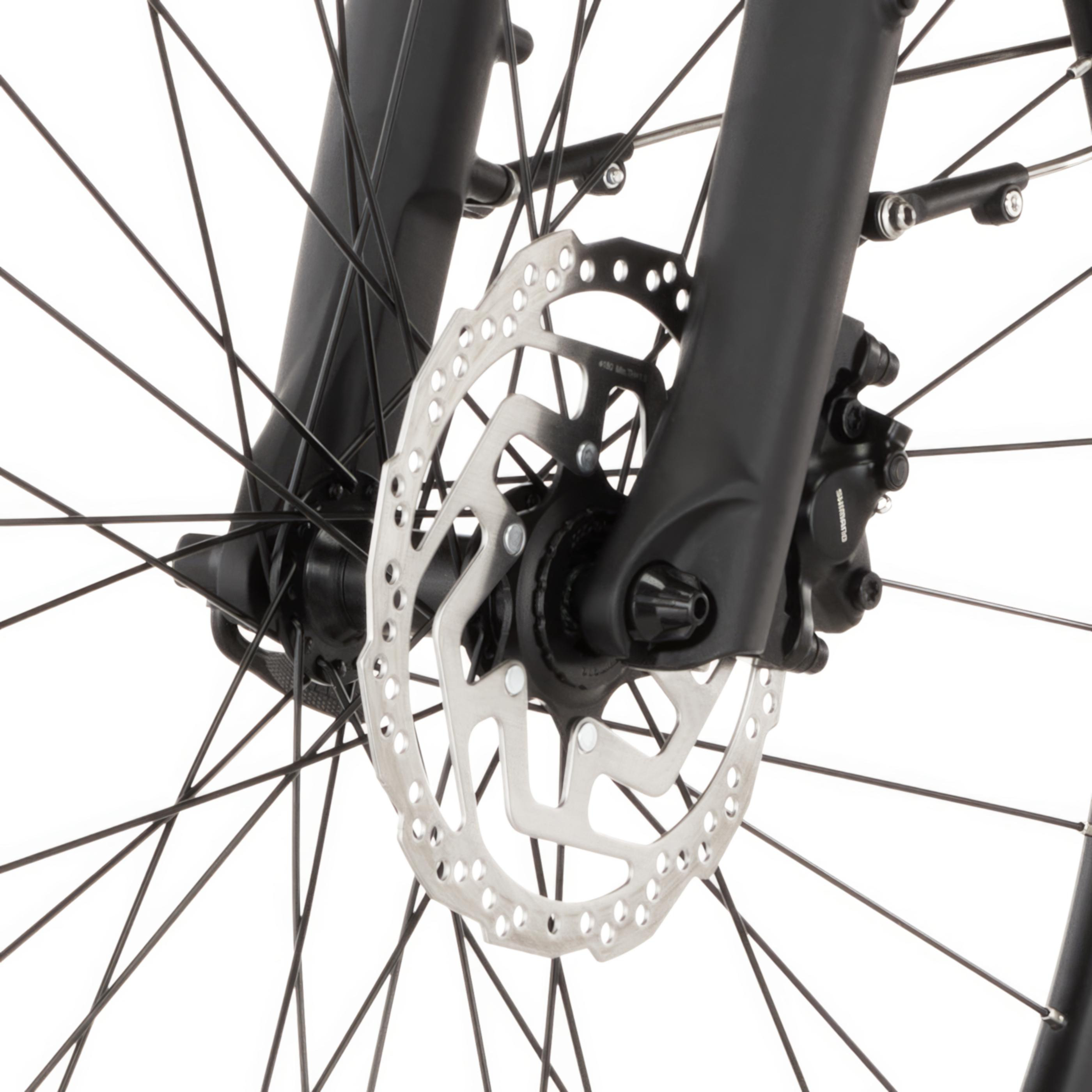 Nahaufnahme eines Fahrrad-Scheibenbremssystems mit Speichen und Gabel.