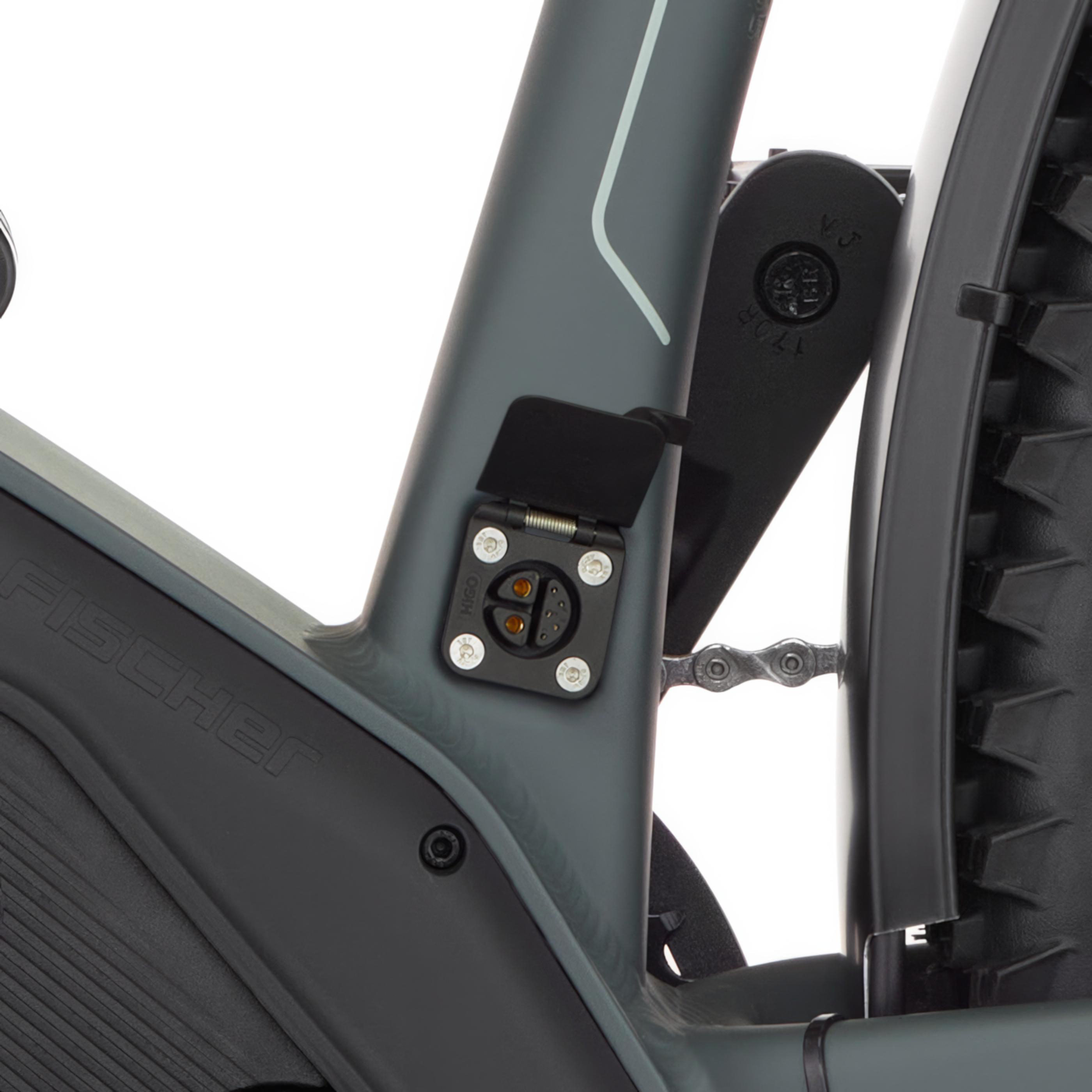 Nahaufnahme des Ladeanschlusses eines grauen Fischer-E-Bikes mit sichtbarer Kette.