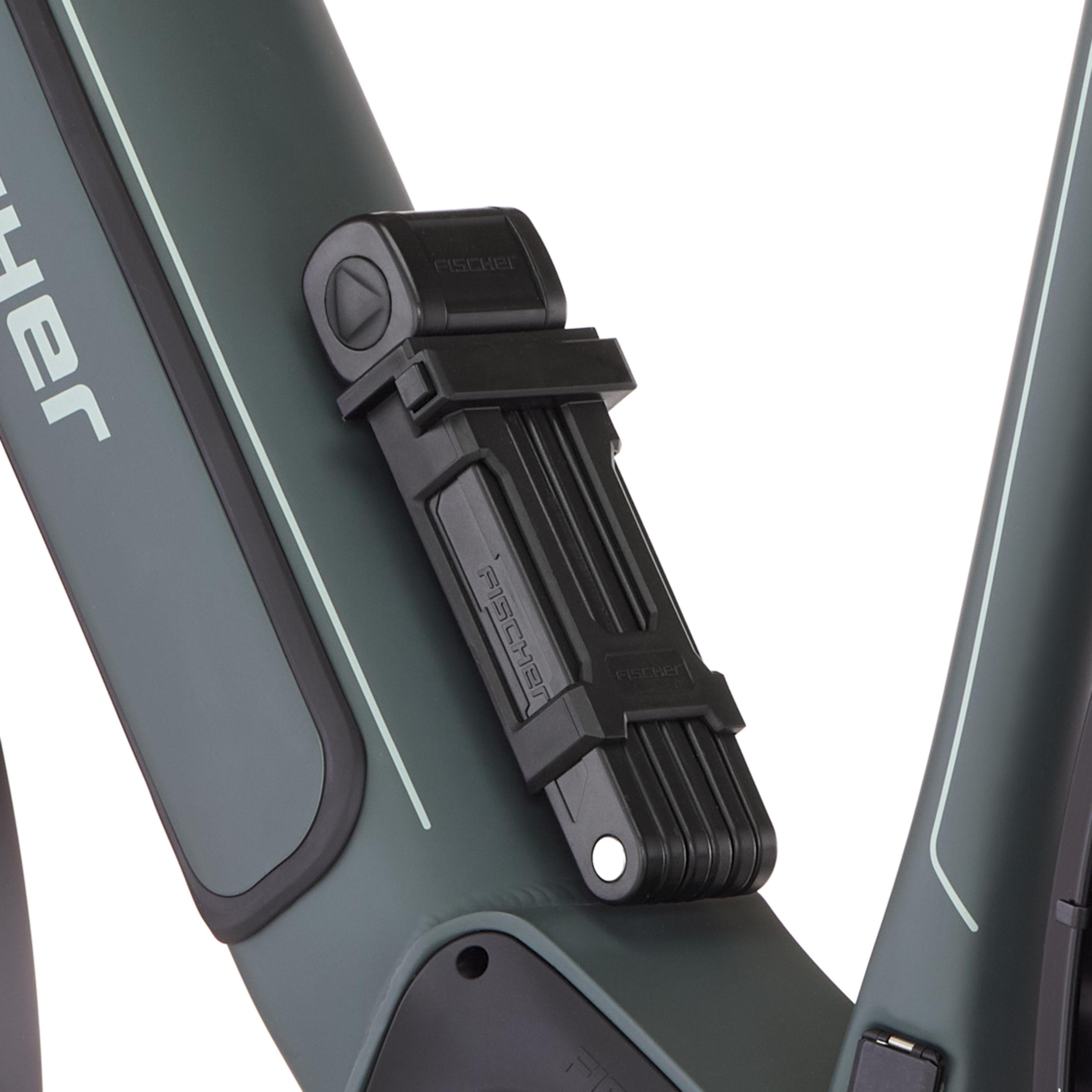 Ein schwarzer faltbarer Fahrradschloss ist an einem dunkelgrünen Fahrradrahmen befestigt.