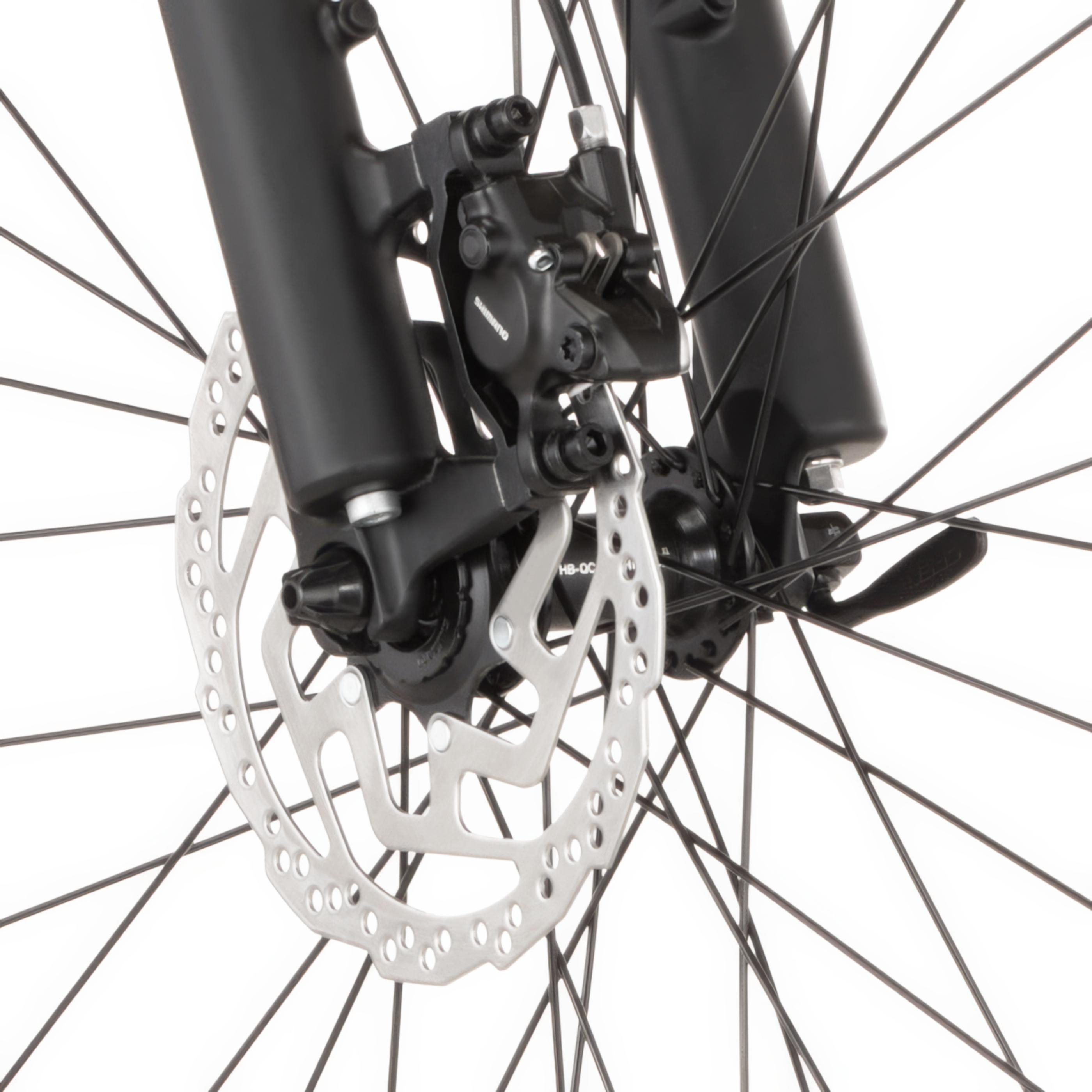 Nahaufnahme einer Fahrradscheibenbremse mit schwarzer Gabel und silberner Bremsscheibe.