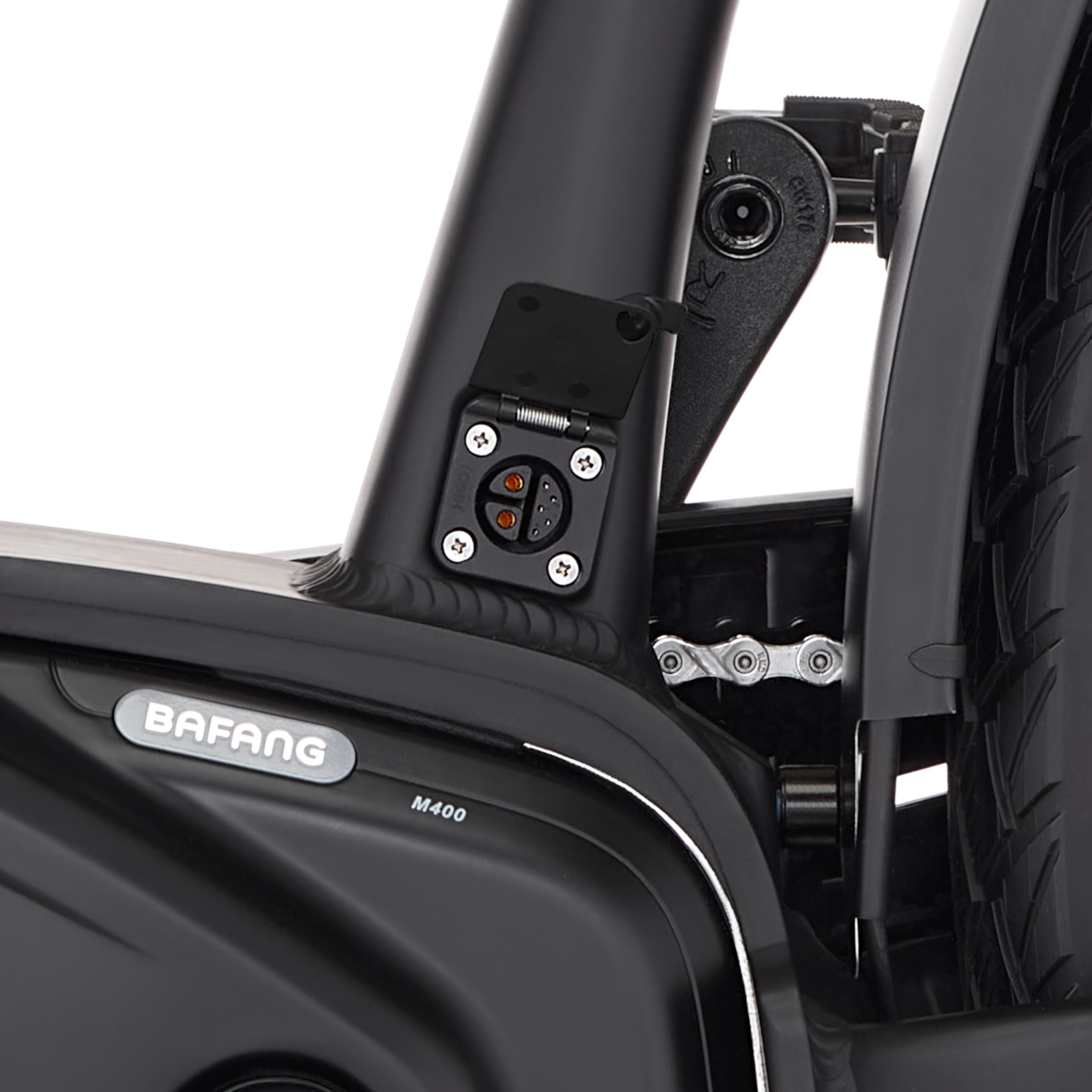Nahaufnahme eines schwarzen E-Bike-Rahmens mit Ladeanschluss und Kette.