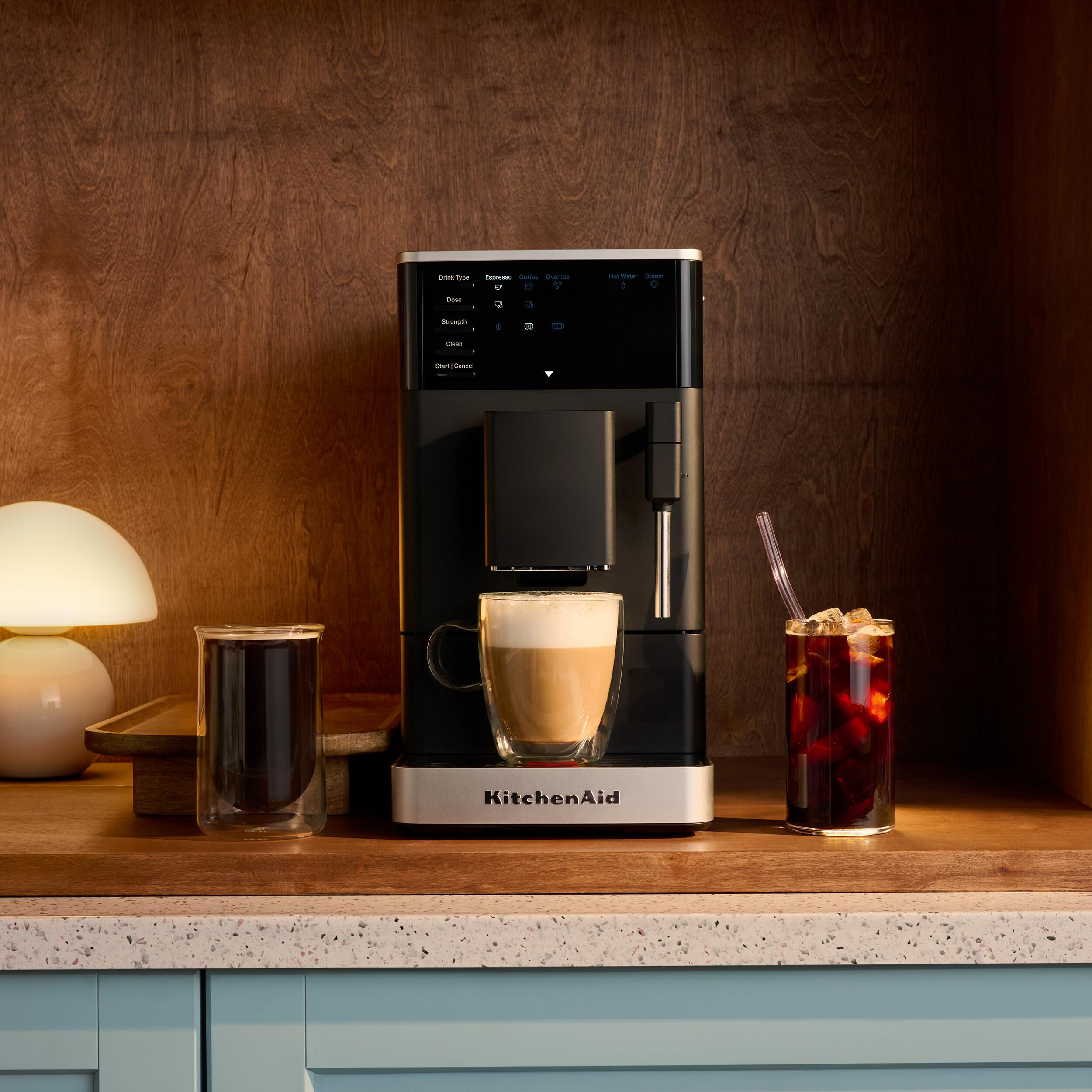 Kaffeemaschine mit zwei Tassen Kaffee und einer Tasse Latte Macchiato.