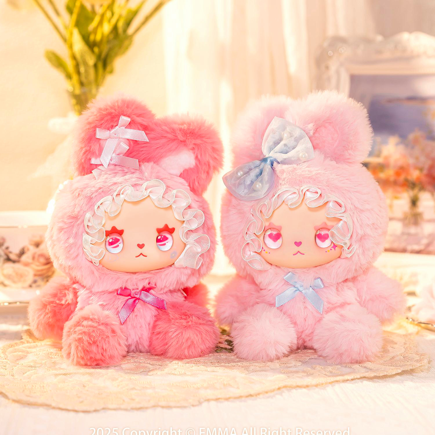 Zwei flauschige rosa Plüschtiere mit Schleifen auf einem Spitzenuntersetzer.