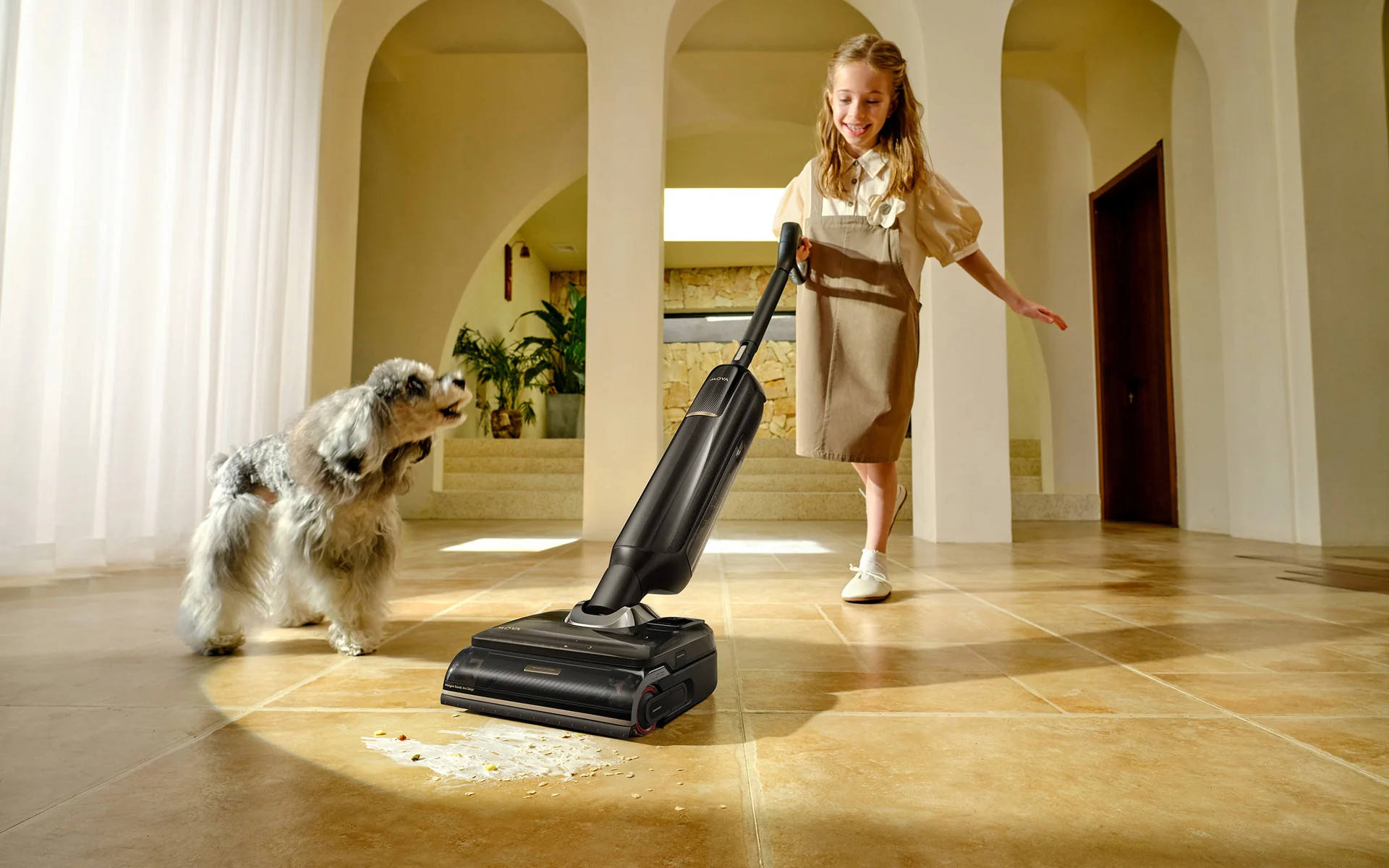 Dziewczynka odkurza rozsypane jedzenie, podczas gdy pies patrzy.