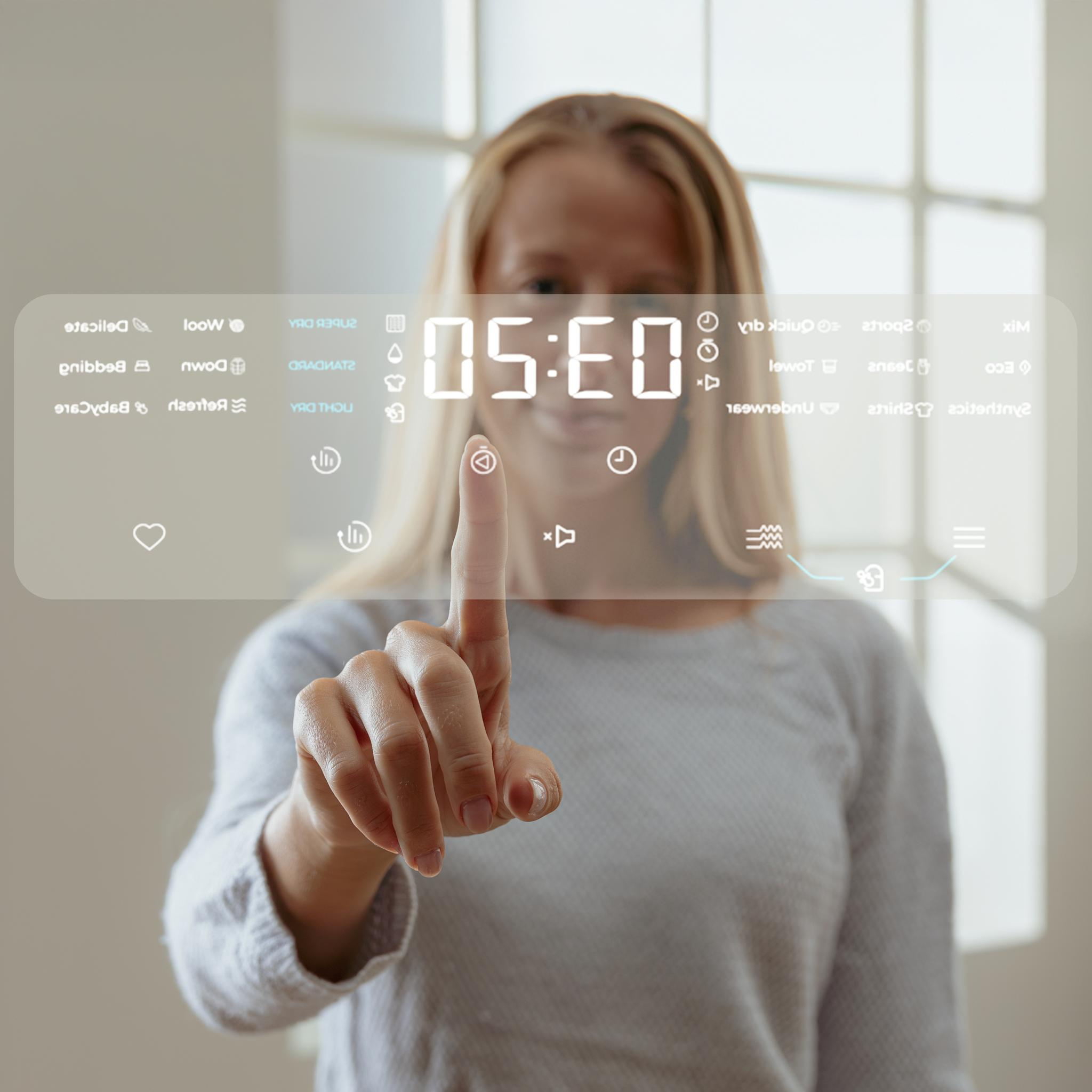 Una mujer toca una pantalla que muestra 05:50 y varios iconos.