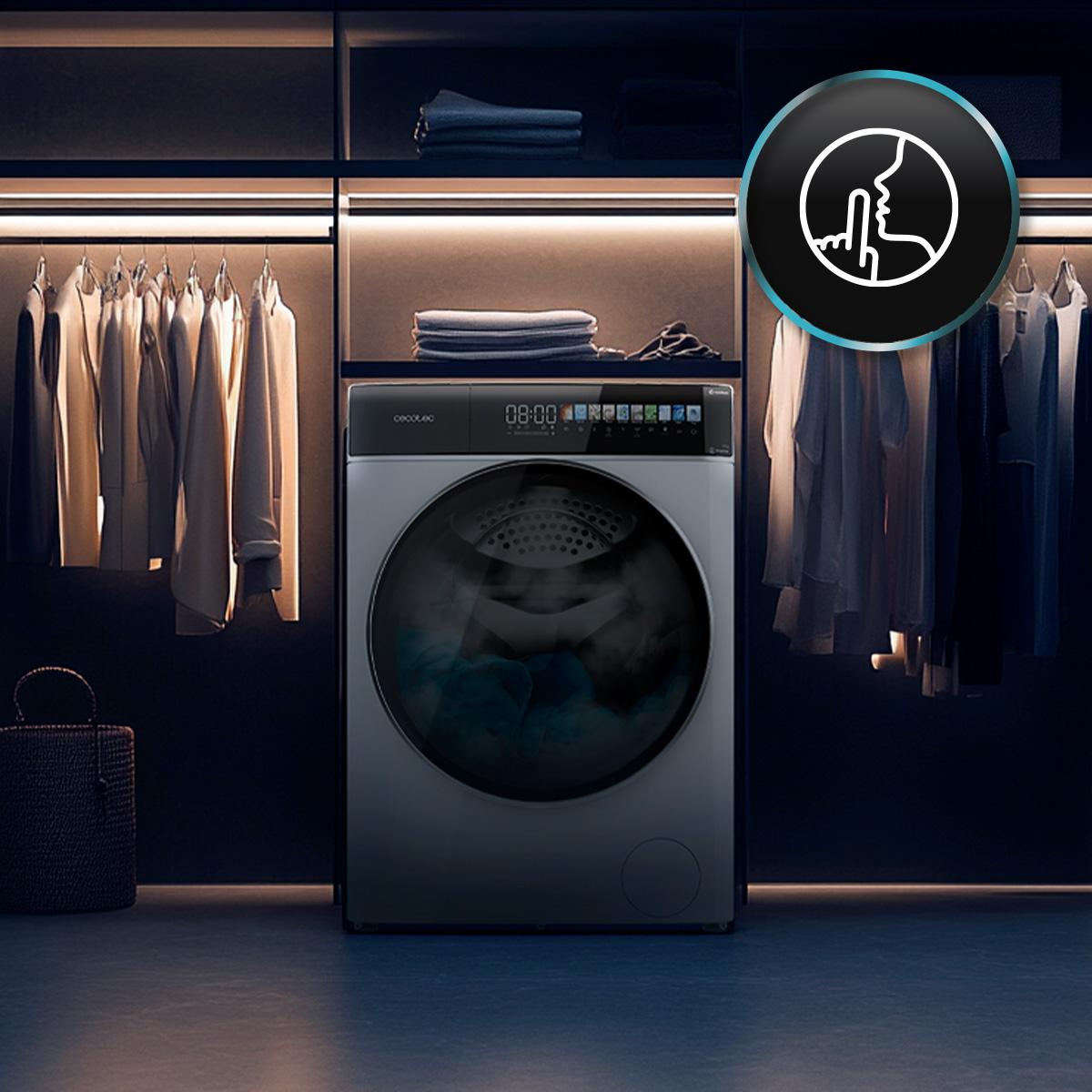 Lavadora moderna en un armario con ropa e iluminación. Se ve un icono de silencio.