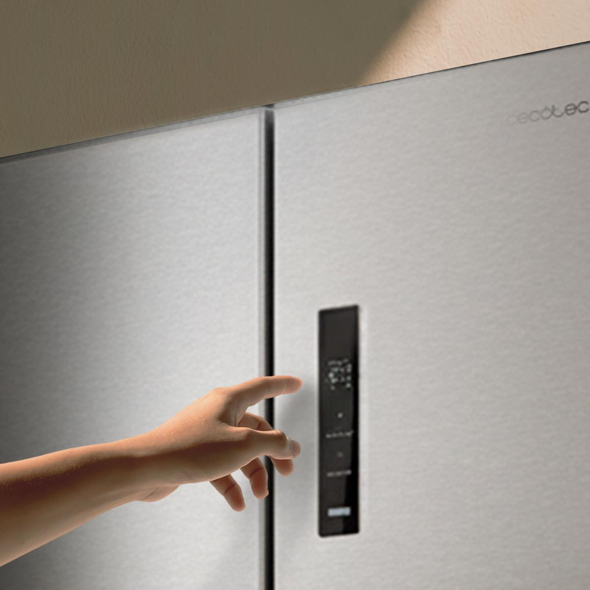 Una mano se extiende hacia un refrigerador moderno y elegante con pantalla digital.
