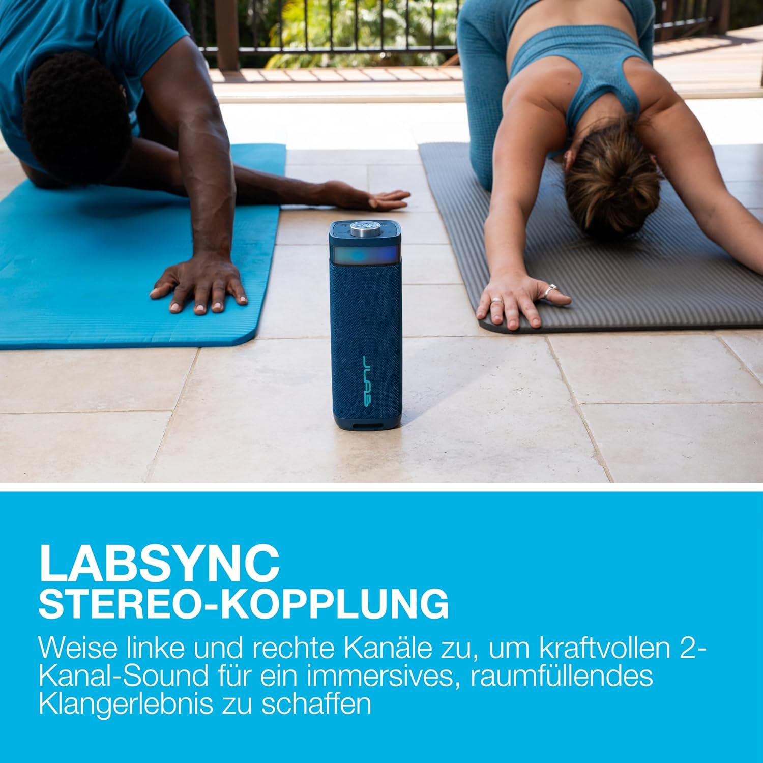 Mann und Frau machen Yoga-Übungen auf Matten mit einem blauen Lautsprecher.
