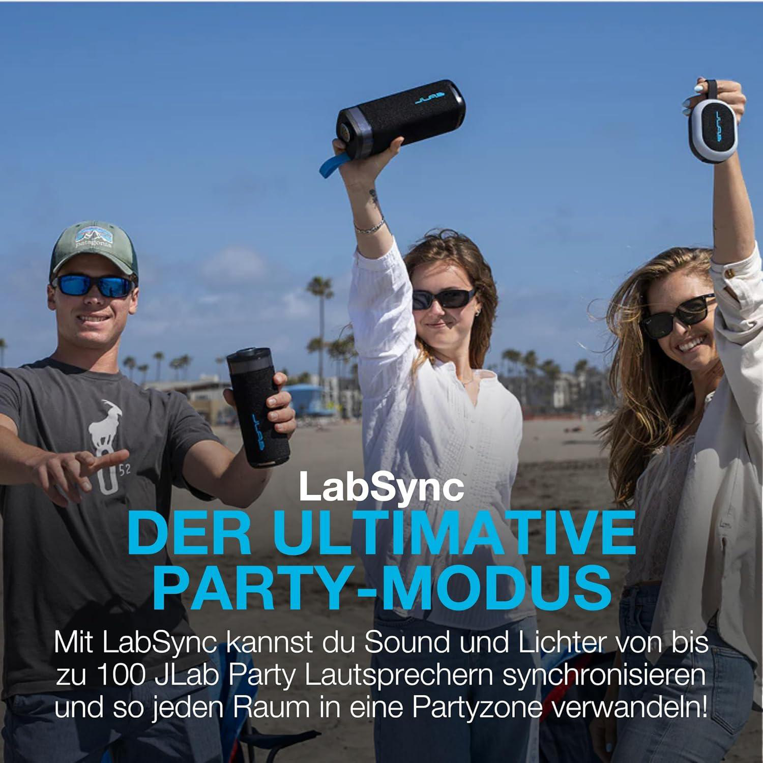 Drei Personen am Strand halten Lautsprecher hoch. LabSync Party Modus.