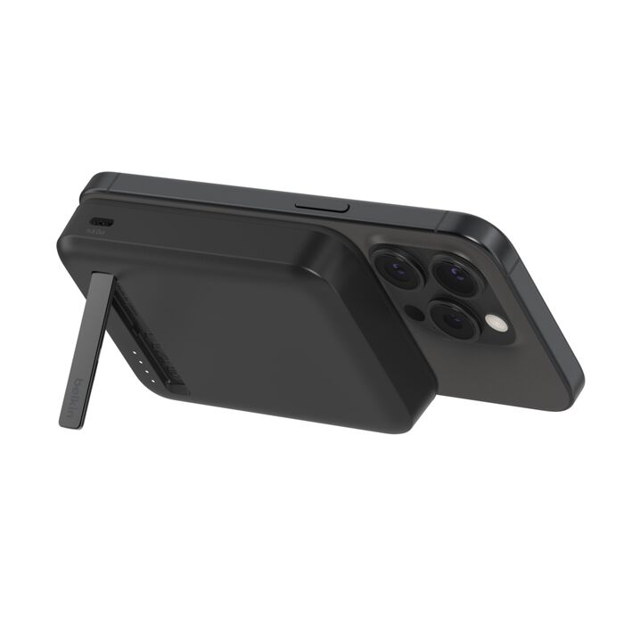 Un iPhone negro con funda de batería acoplada, vista lateral, fondo blanco.
