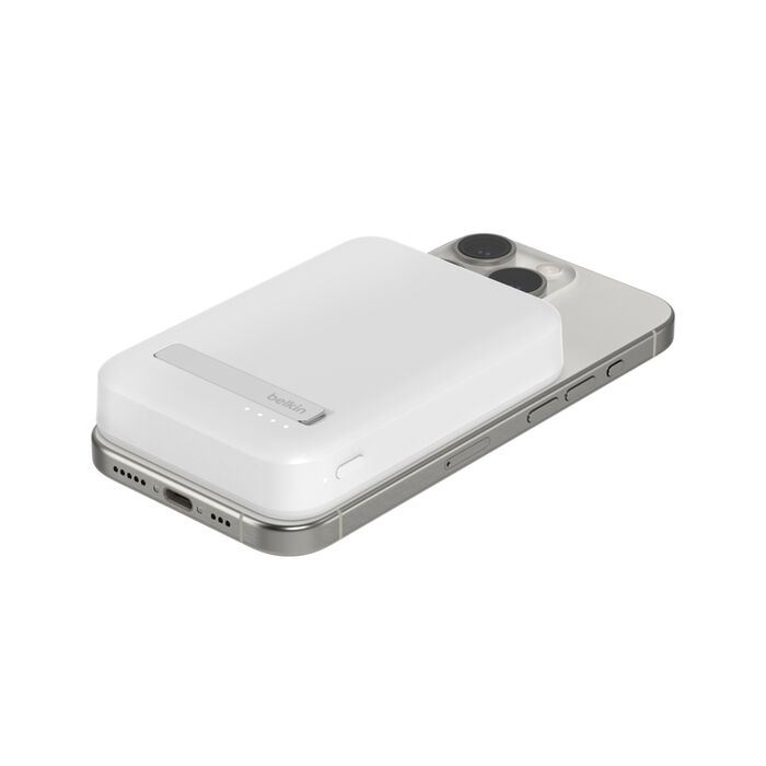 Un estuche de carga blanco está acoplado a la parte trasera de un iPhone plateado.