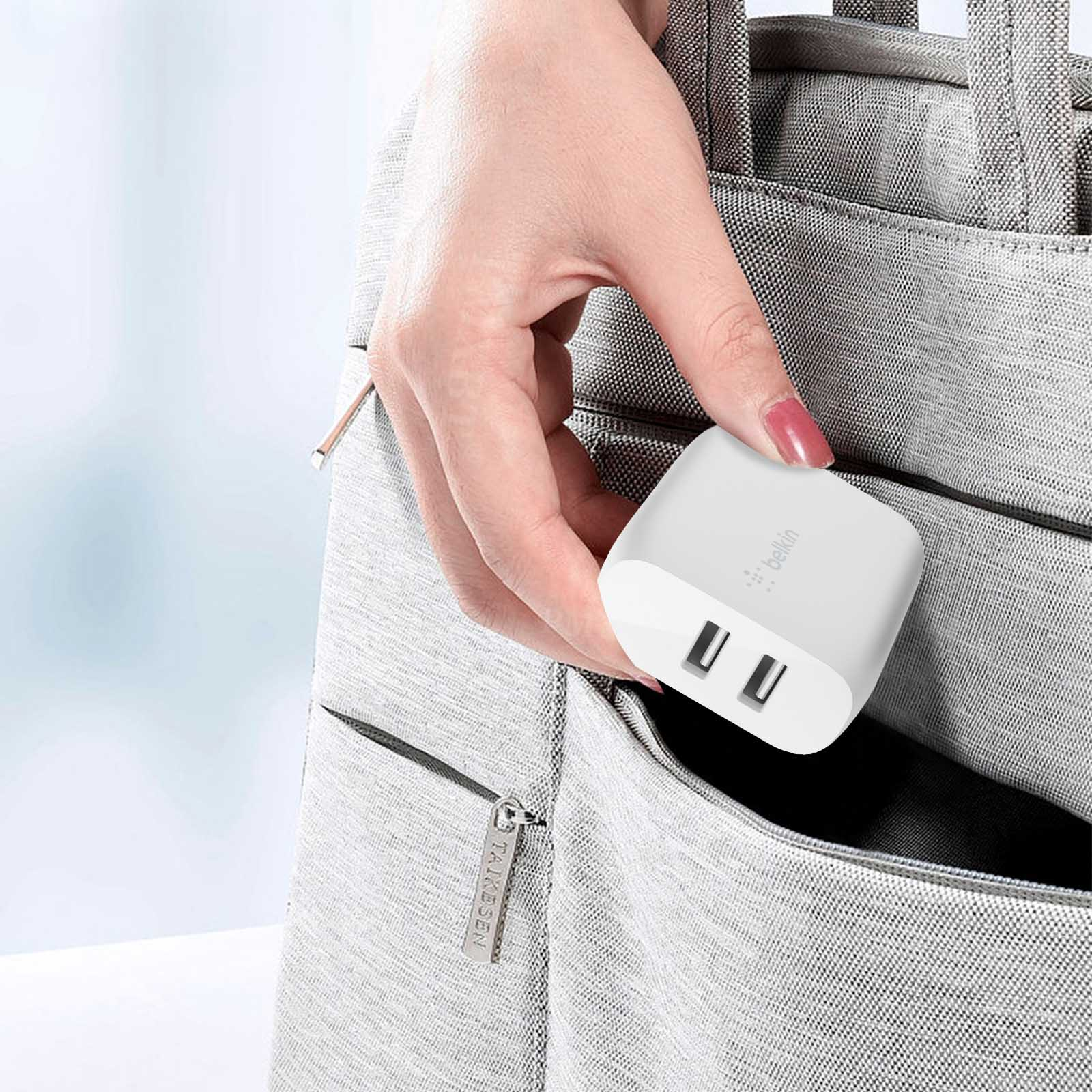 Cargador blanco dual USB se coloca en una bolsa de tela gris.